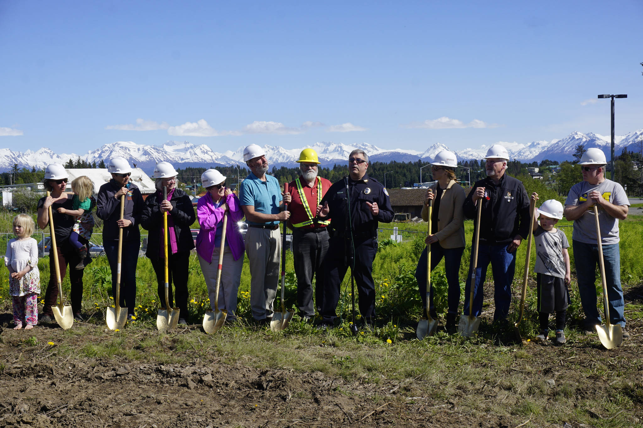 Homer Police Chief Mark Robl, center, speaks at the groundbreaking ceremony for the new Homer Police Station on Grubstake Avenue last Friday, May 24, 2019, in Homer, Alaska. From left to right are Homer City Council member Rachel Lord with her two children, Sadie and Linnea, council member Donna Aderhold, council member Shelly Erickson, council member Caroline Venuti, former Homer Mayor Bryan Zak, Mayor Ken Castner, Robl, Homer City Manager Katie Koester, and Byron Smith, son of council member Heath Smith, far right. (Photo by Michael Armstrong/Homer News)