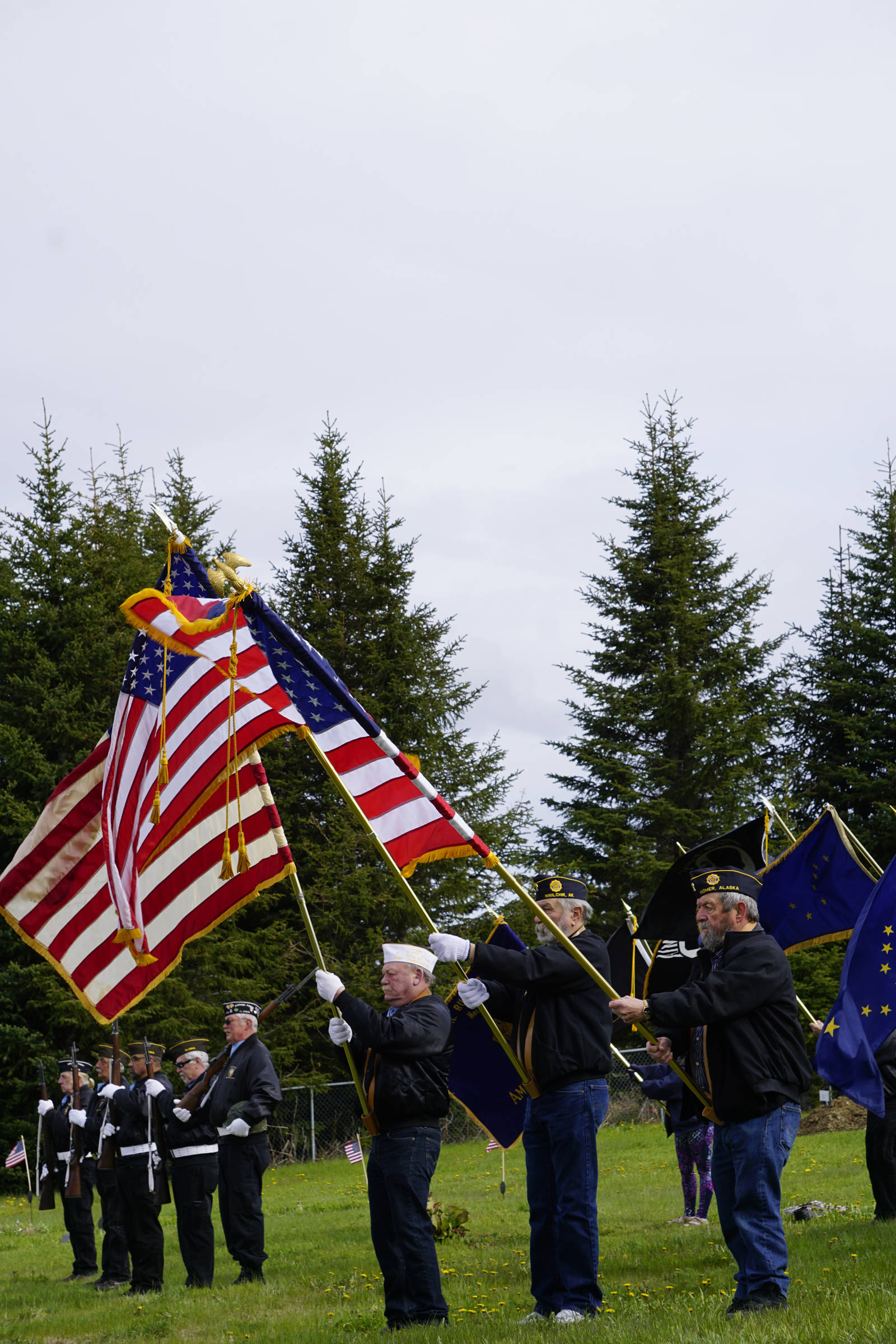 Members of the Veterans of Foreign Wars, the American Legion, Homer and Ninilchik posts, the American Legion Auxiliary and the Sons of the American Legion hold an honor guard at Memorial Day ceremonies on Monday, May 27, 2019, at Hickerson Memorial Cemetery in Homer, Alaska. About 75 people braved a blustery wind to attend the ceremonies. (Photo by Michael Armstrong/Homer News)