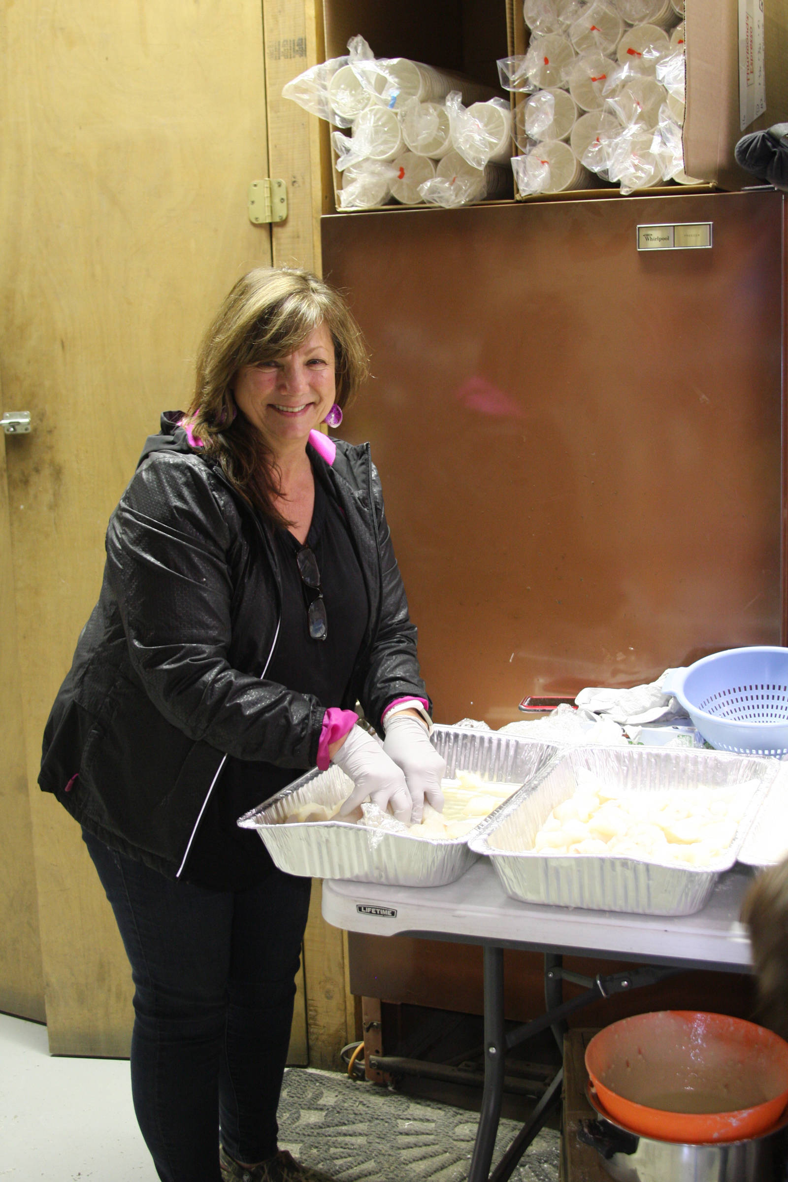 Elaine Griner helps prepare freshly caught halibut for the fifth annual Customer Appreciation Day and 50th anniversary celebration on Saturday, May 25 at Thurmond’s Far West Auto in Anchor Point, Alaska. (Photo by Delcenia Cosman)