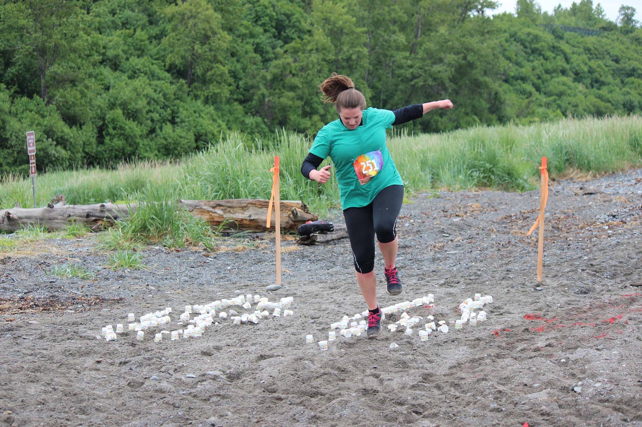 Danielle Harrison, 251, navigates through a sandy hopscotch course, one of several challenges added to the 5K fun run, the Clam Scramble held Saturday, June 15, 2019 in Ninilchik, Alaska. (Photo by McKibben Jackinsky)
