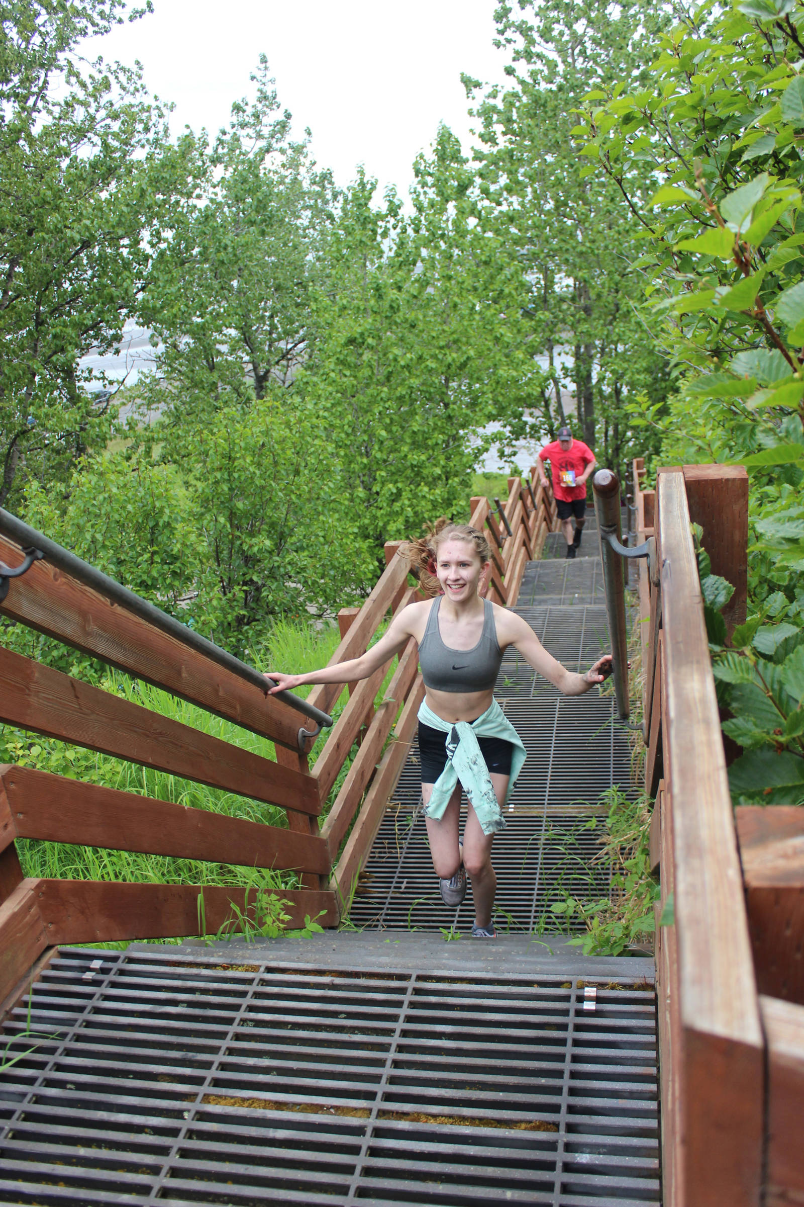 A smiling Jaycee Corey tackles the last challenge in the 2019 Clam Scramble: 115 stairs leading from Ninilchik beach to the finish line at the race held Saturday, June 15, 2019 in Ninilchik, Alaska. (Photo by McKibben Jackinsky)