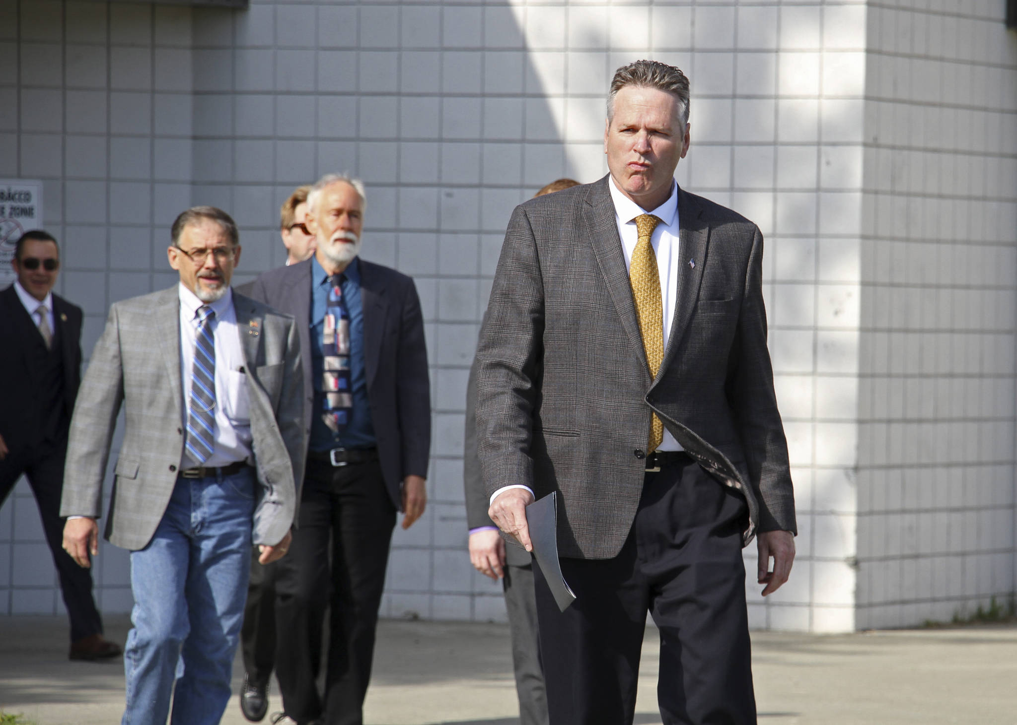 Alaska Gov. Mike Dunleavy walks to the podium at a news conference Friday, June 14, 2019, in Wasilla, Alaska. Dunleavy has called lawmakers into special session July 8 in Wasilla, and his administration gave a tour of the recommended site at Wasilla Middle School to reporters. (AP Photo/Mark Thiessen)