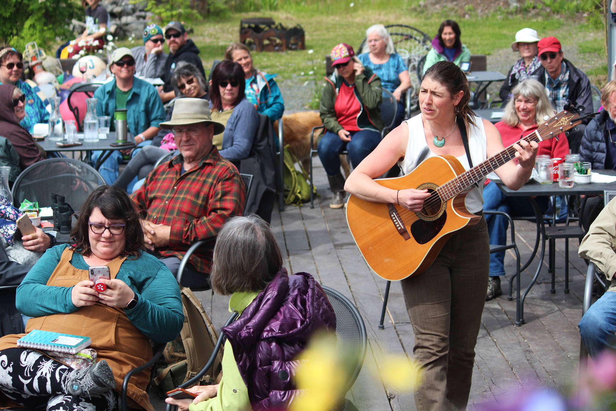 Kat Moore walks through the assembled crowd while she plays her set at the Seldovia Boardwalk Hotel on Friday, June 21, 2019 as part of a round of street performances during the Seldovia Summer Solstice Music Festival in Seldovia, Alaska. (Photo by Megan Pacer/Homer News)
