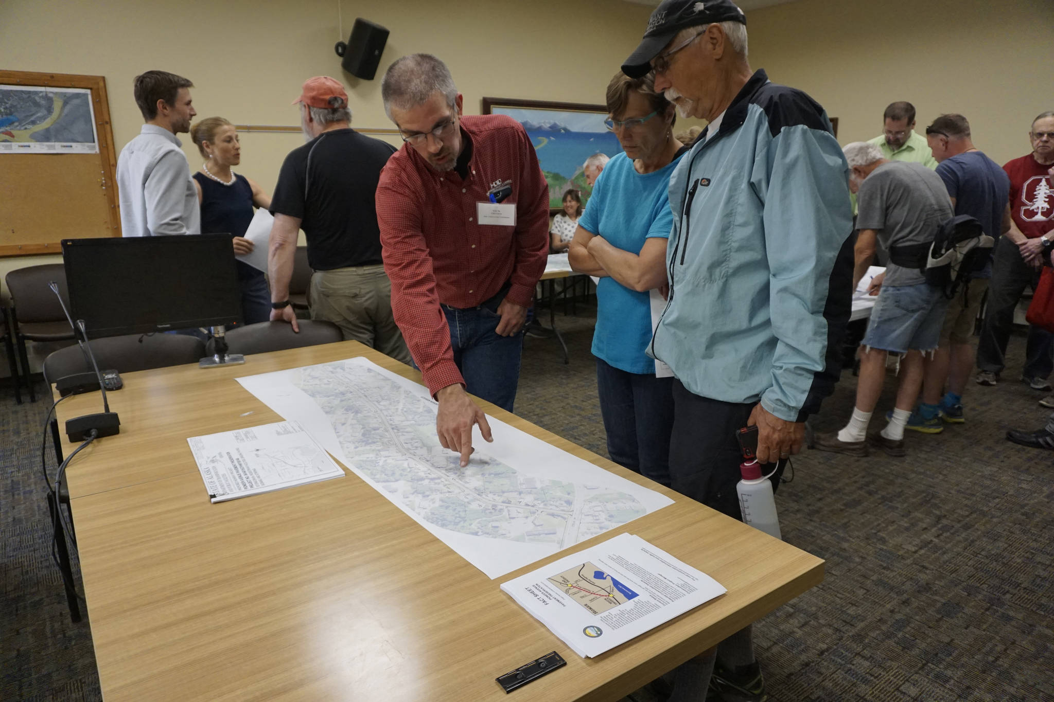 Nick Oliveira of HDL Engineering Consultants, left, talks about the Pioneer Avenue pavement preservation project with Homer City Council Member Donna Aderhold, center, and Wayne Aderhold, right, at a public meeting on current and upcoming ADOT&PF projects on June 25, 2019, at Homer City Hall, Homer, Alaska. (Photo by Michael Armstrong/Homer News)