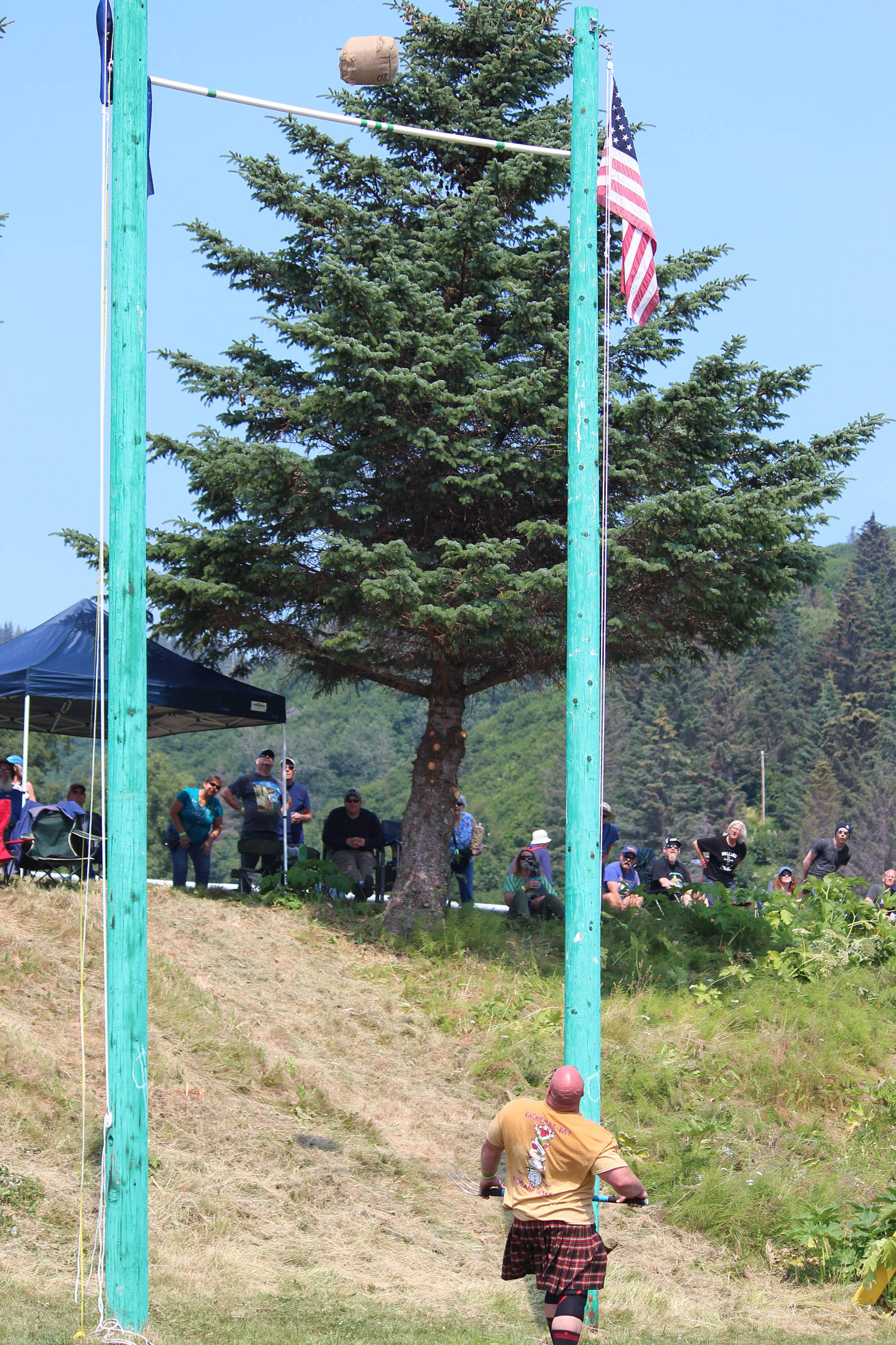 Robert Moody watches the sheaf he just threw with a pitchfork soar over the bar in the men’s sheaf throw competition at this year’s Kachemak Bay Highland Games on Saturday, July 6, 2019 at Karen Hornaday Park in Homer, Alaska. (Photo by Megan Pacer/Homer News)