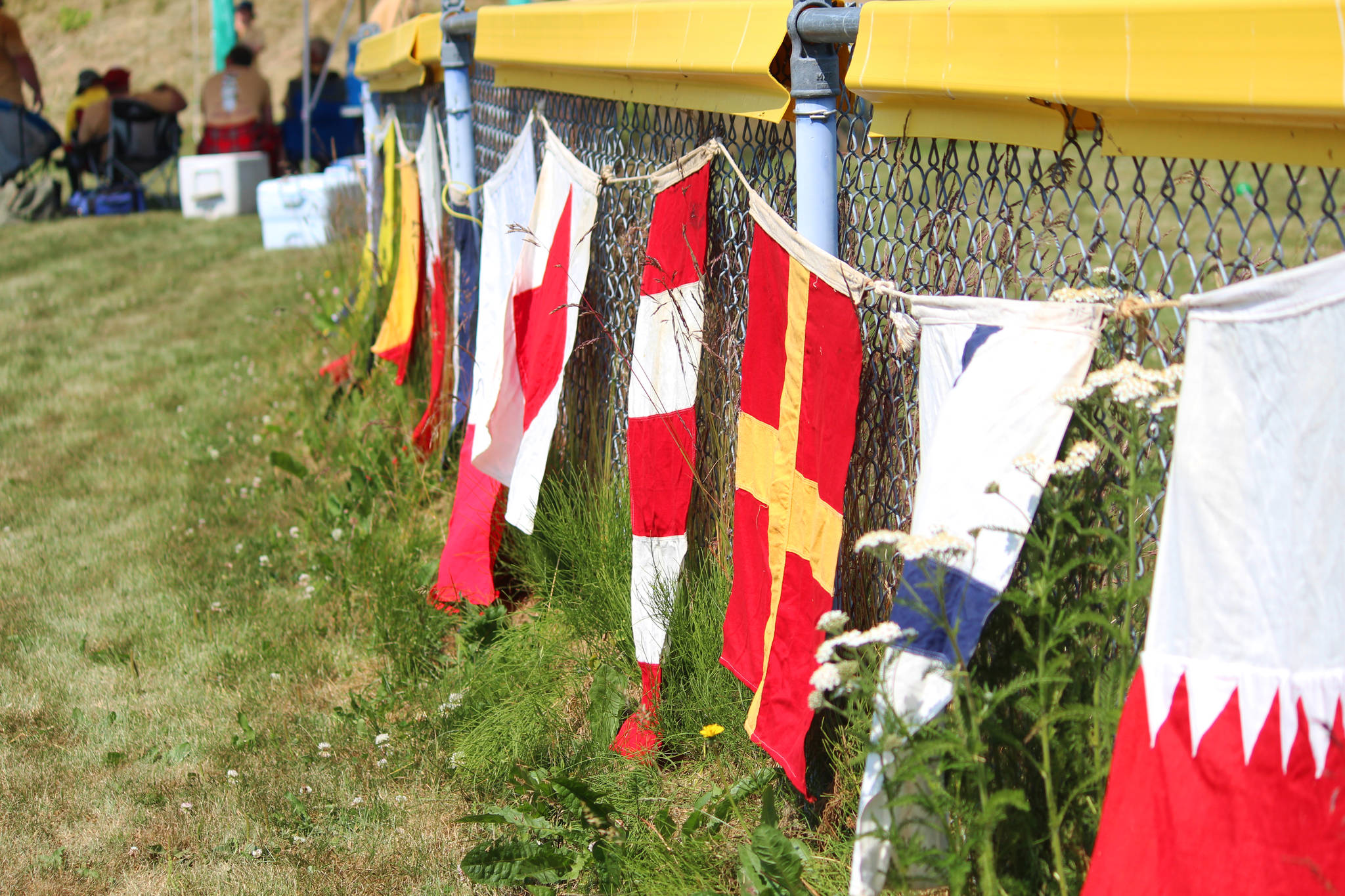 Decorative flags line a fence at the annual Kachemak Bay Highland Games held Saturday, July 6, 2019 at Karen Hornaday Park in Homer, Alaska. (Photo by Megan Pacer/Homer News)