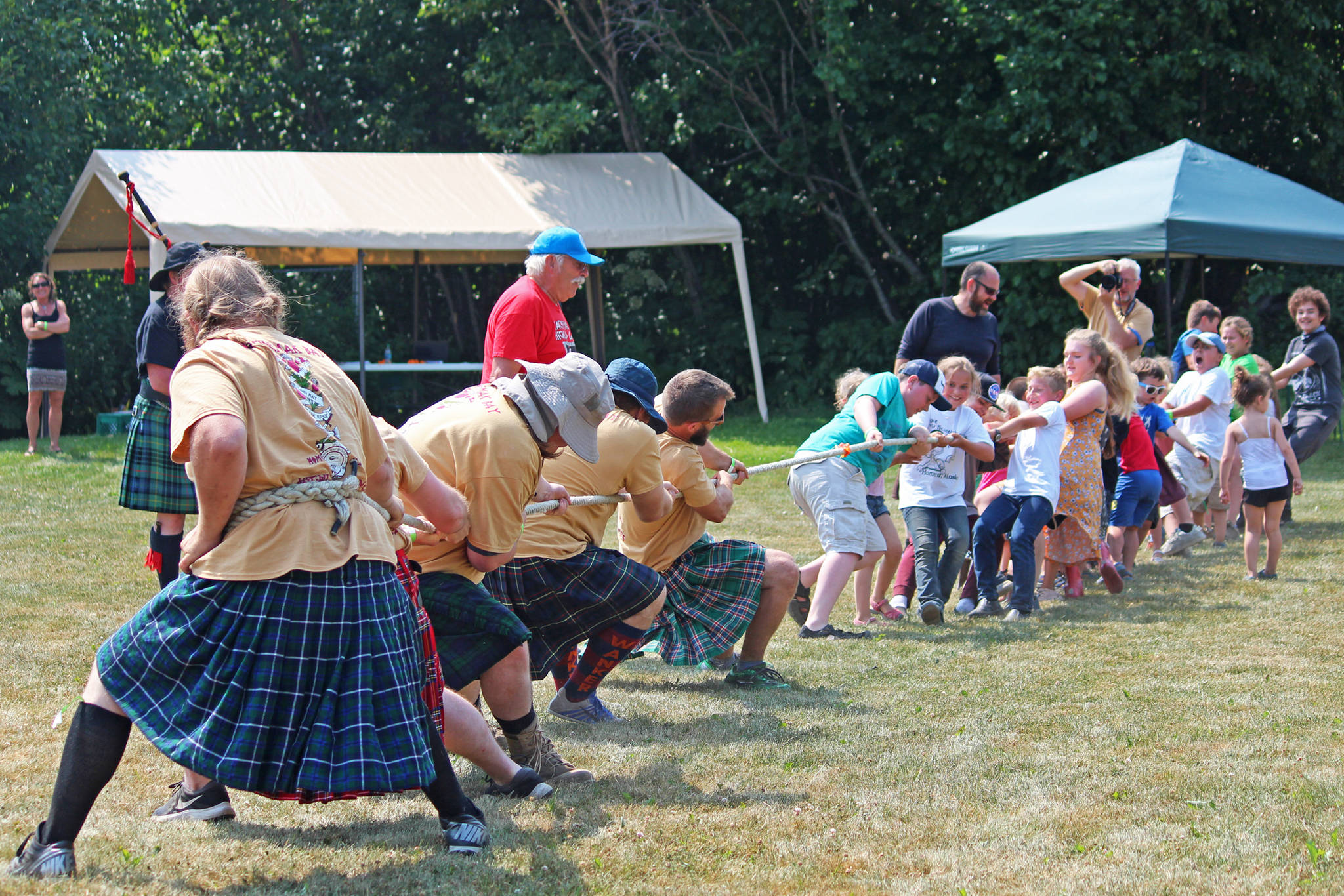 Competitors in this year’s Kachemak Bay Highland Games struggle to hold their ground against a large group of children.
