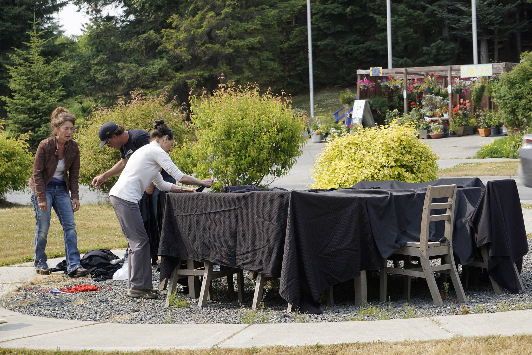 From left to right, artists Asia Freeman, Michael Walsh and Rika Mouw on July 9, 2019, drape a Sean Derry’s public art sculpture in Homer, Alaska, as part of a statewide art intervention to protest Gov. Mike Dunleavy’s veto of a $2.8 million state appropriation to the Alaska State Council on the Arts. They also supported a general override of Dunleavy’s vetoes that will affect funding for the University of Alaska, public radio and other programs. Derry’s sculpture was commissioned as a 1% for art project associated with the remodeling of Pioneer Hall at the Kachemak Bay Campus, Kenai Peninsula College, University of Alaska. The protest was not sanctioned by the college. (Photo by Michael Armstrong/Homer News)