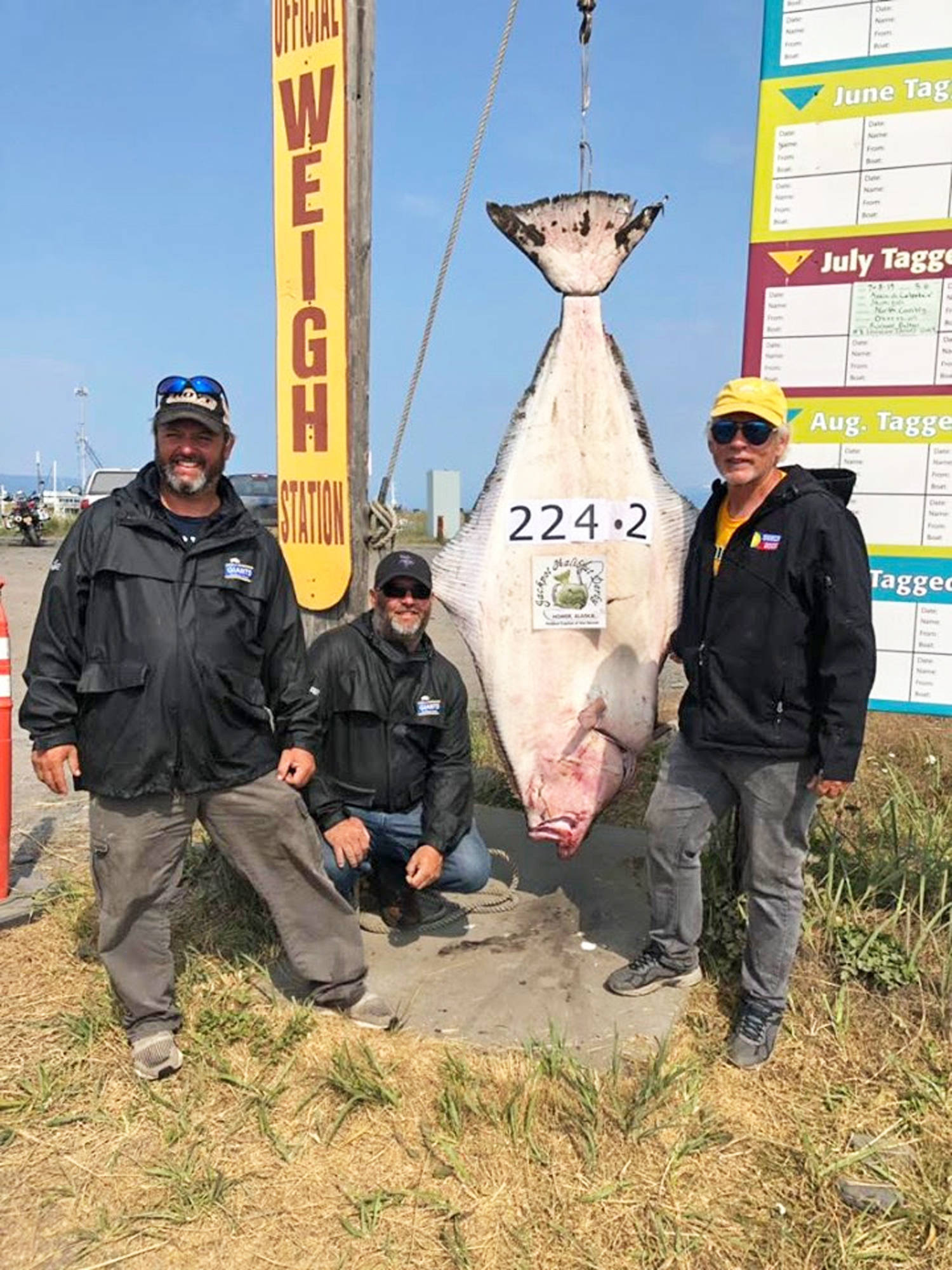 Photo courtesy Homer Chamber of Commerce                                Jason Schuler of Wahpeton, North Dakota (left) poses with his 224-pound halibut, caught July 12, 2019 near Homer, Alaska. He is the new leader in the Jackpot Halibut Derby.