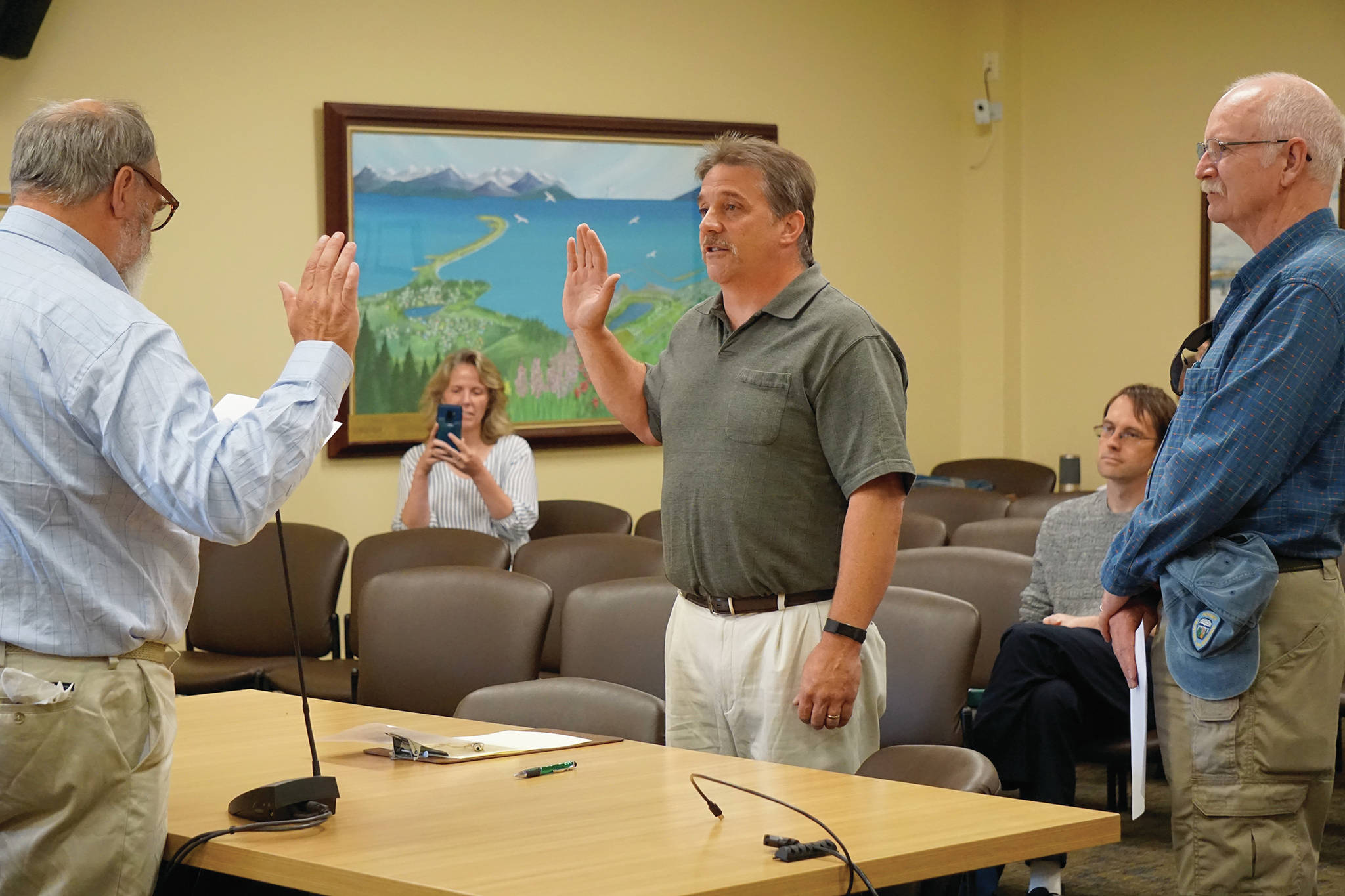 Homer Mayor Ken Castner, left, swears in new Homer Volunteer Fire Department Chief Mark Kirko, center, as former Acting Chief Robert Purcell, right, watches at the Homer City Council regular meeting held July 22, 2019, in the Cowles Council Chambers, Homer City Hall, in Homer, Alaska. Castner also read a letter of appreciation to Purcell, a former HVFD fire chief, thanking him for coming out of retirement to serve as acting chief. (Photo by Michael Armstrong/Homer News)