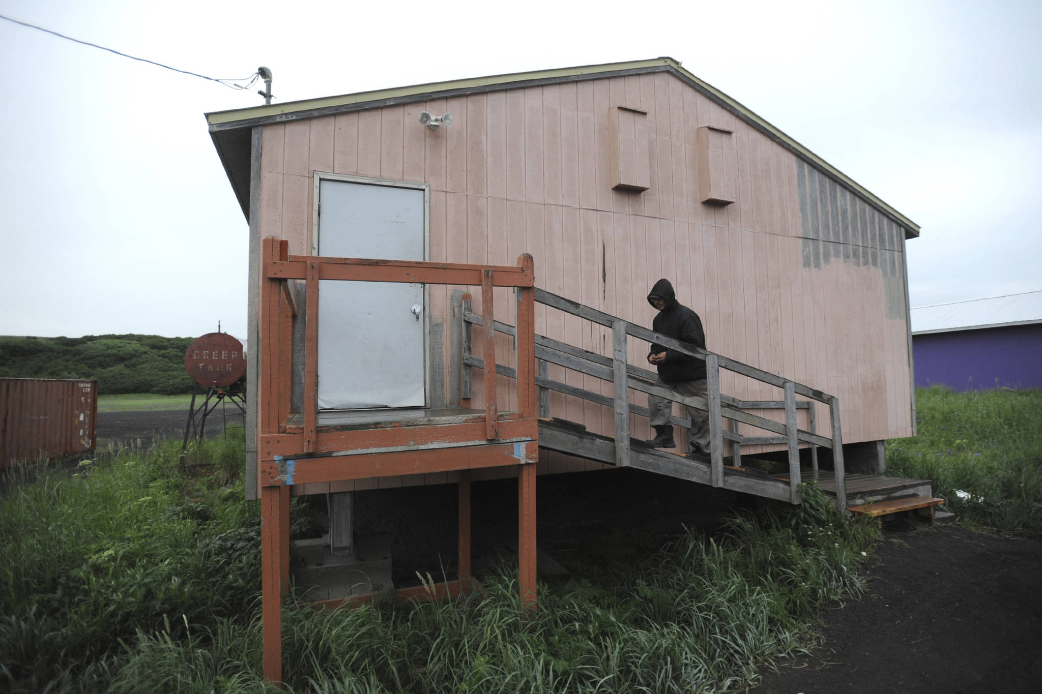 In this Wednesday, June 26, 2019 photo, Stebbins Village Police Officer John Aluska enters the public safety building in the Yup’ik village of Stebbins, Alaska, which houses the police department and three jail cells. Aluska has a criminal record but said it does not interfere with his police work. At least 14 cities in Alaska have employed police officers whose criminal records should have prevented them from being hired under state law, the Anchorage Daily News and ProPublica reported Saturday, July 20. (Bill Roth/Anchorage Daily News via AP)