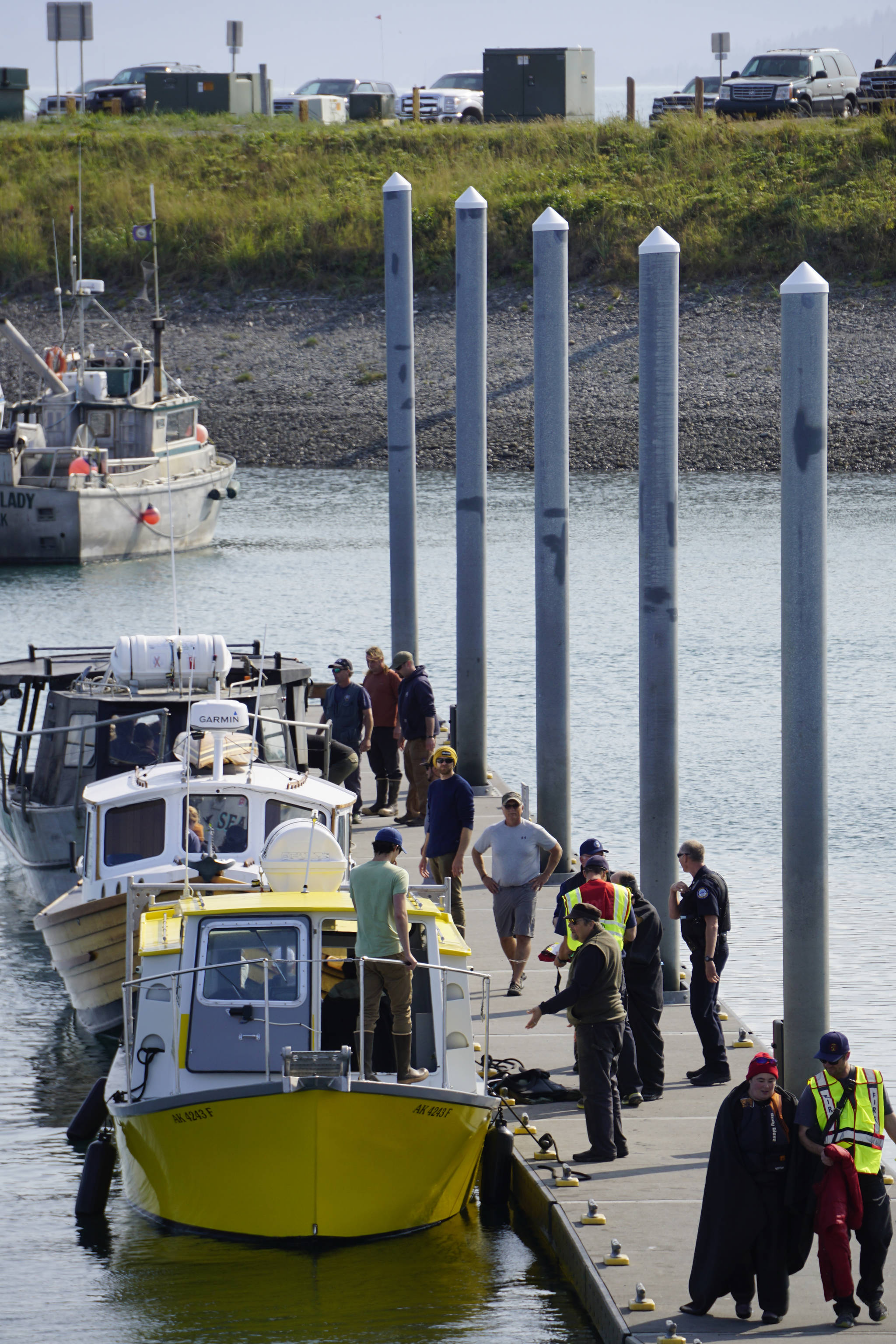 Emergency medical technicians help victims of a boat capsizing up the Homer Harbor load and launch ramp on Tuesday afternoon, July 30, 2019, in Homer, Alaska. Crews in three Good Samaritan boats, from front to back, the Torega, the Grotta Nove, and the Seabird, rescued five people from an overturned skiff near China Poot Bay. (Photo by Michael Armstrong/Homer News)