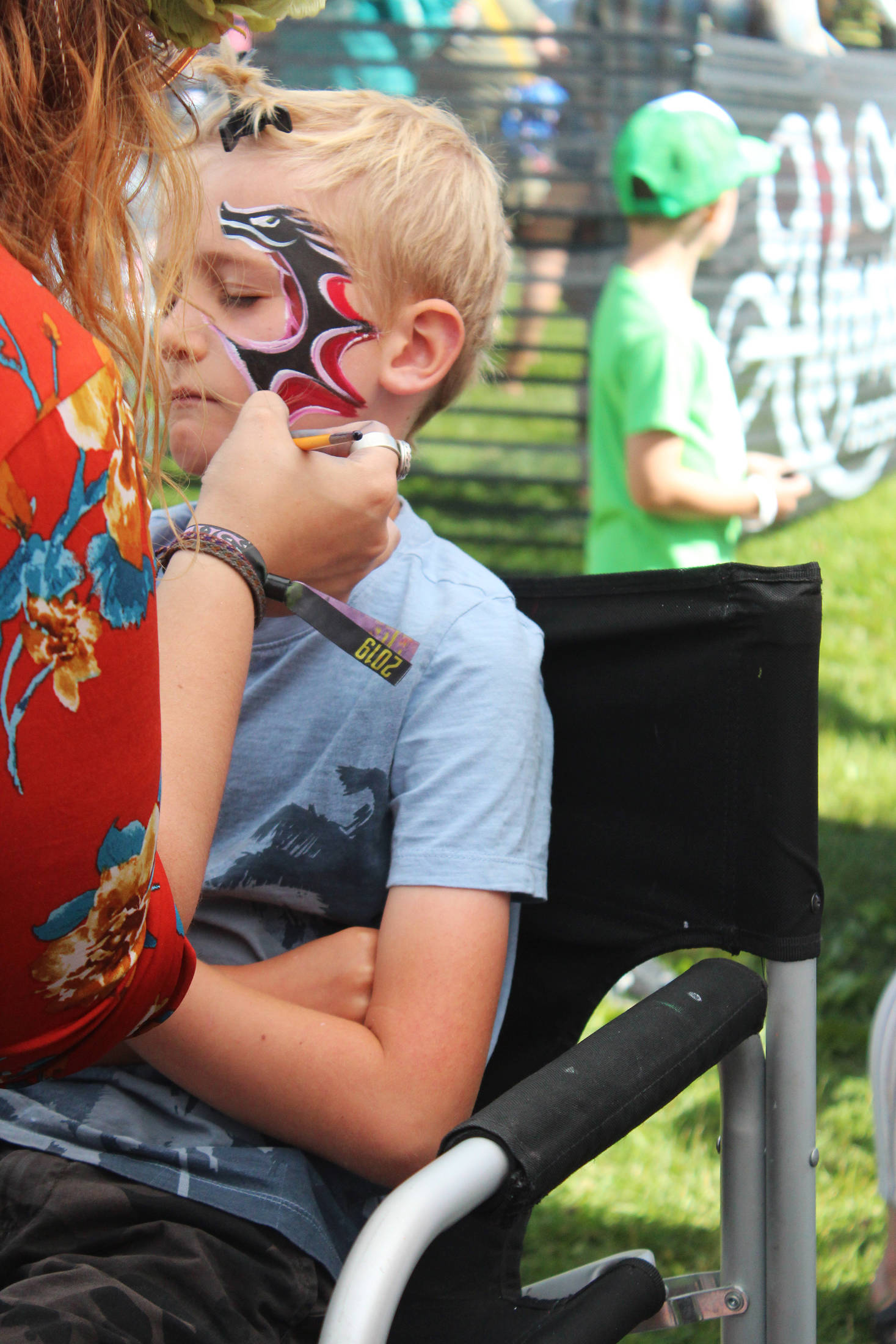 Iver Ledahl, 8, of Kenai, gets his face painted on Friday, Aug. 2, 2019 at Salmonfest in Ninilchik, Alaska. (Photo by Megan Pacer/Homer News)
