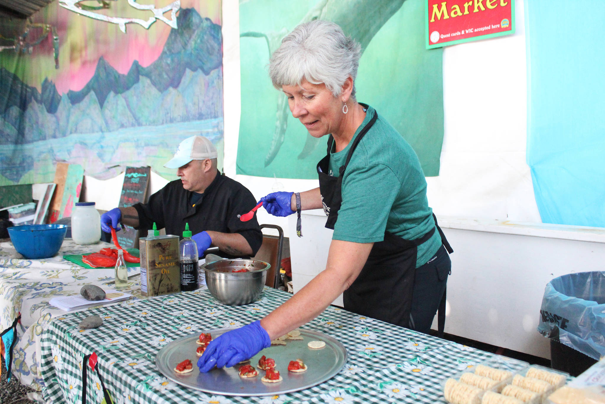 Margarida Kondak lays out salmon poke for festival goers to try during a chef at the festival food demonstration Friday, Aug. 2, 2019 at Salmonfest in Ninilchik, Alaska. (Photo by Megan Pacer/Homer News)