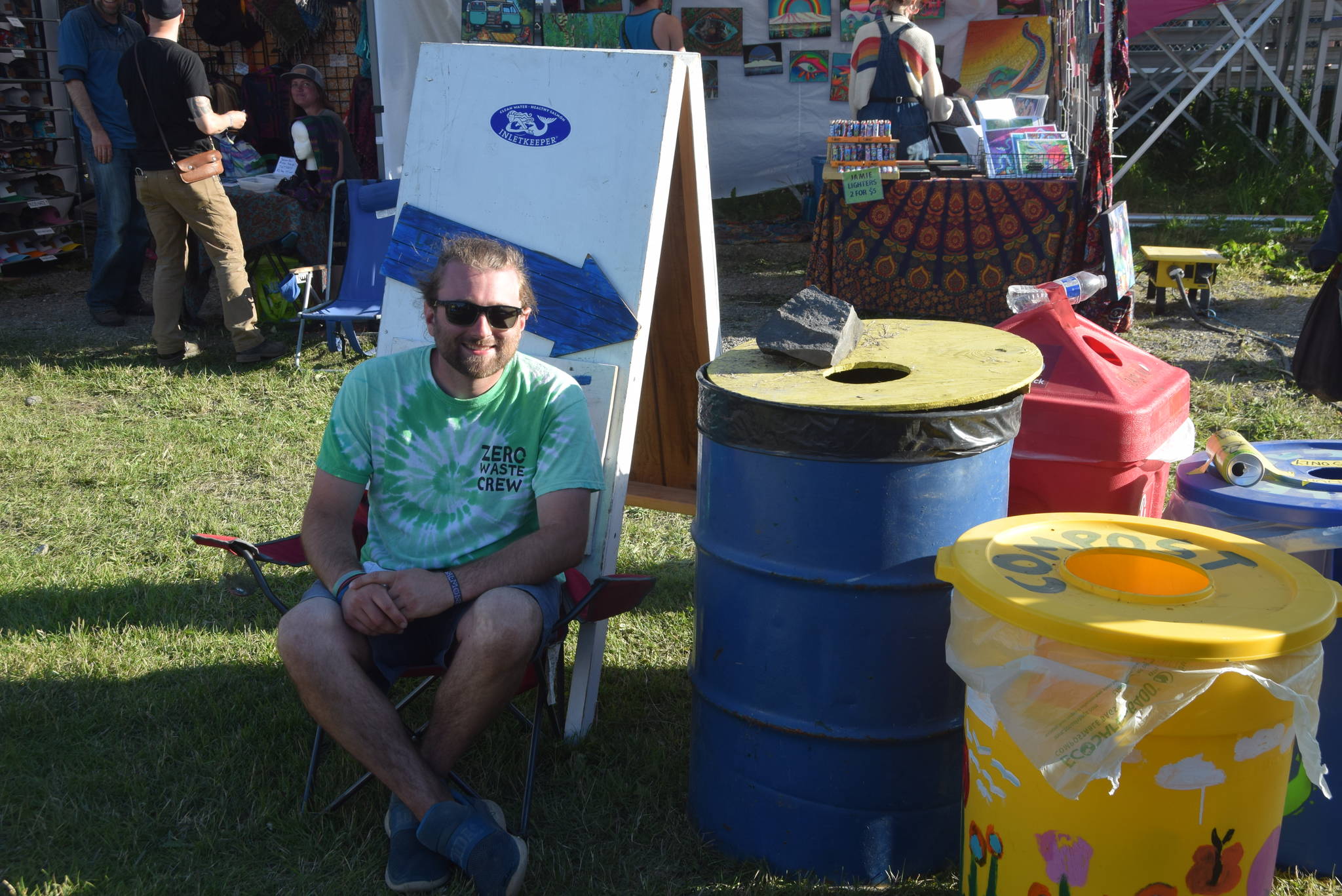 Zero Waste Volunteer Organizer Ryan Astalos smiles for the camera at one of the waste disposal stations during Salmonfest 2019 in Ninilchik, Alaska on August 2, 2019. (Photo by Brian Mazurek/Peninsula Clarion)