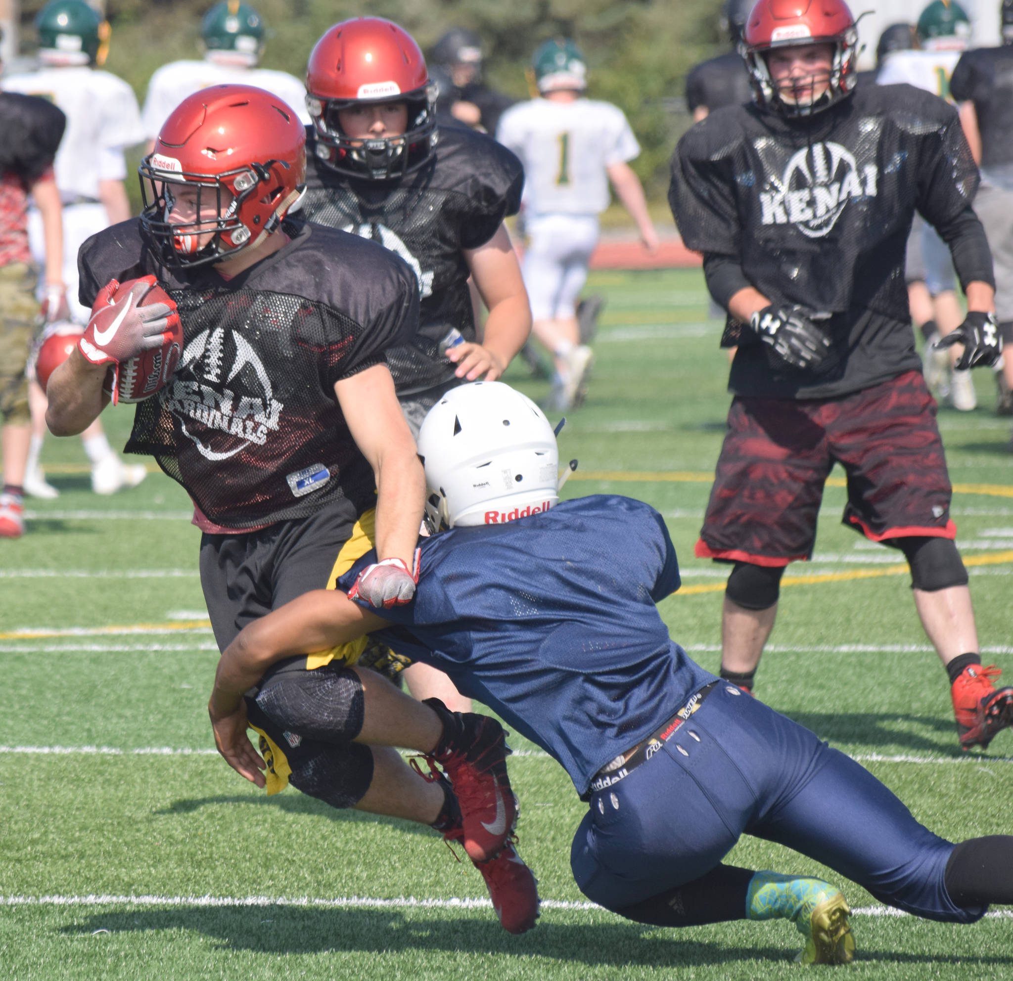 Photo by Jeff Helminiak/Peninsula Clarion                                 Zach Burnett of Kenai Central runs against Homer during a scrimmage Saturday, Aug. 10, at Ed Hollier Field in Kenai.