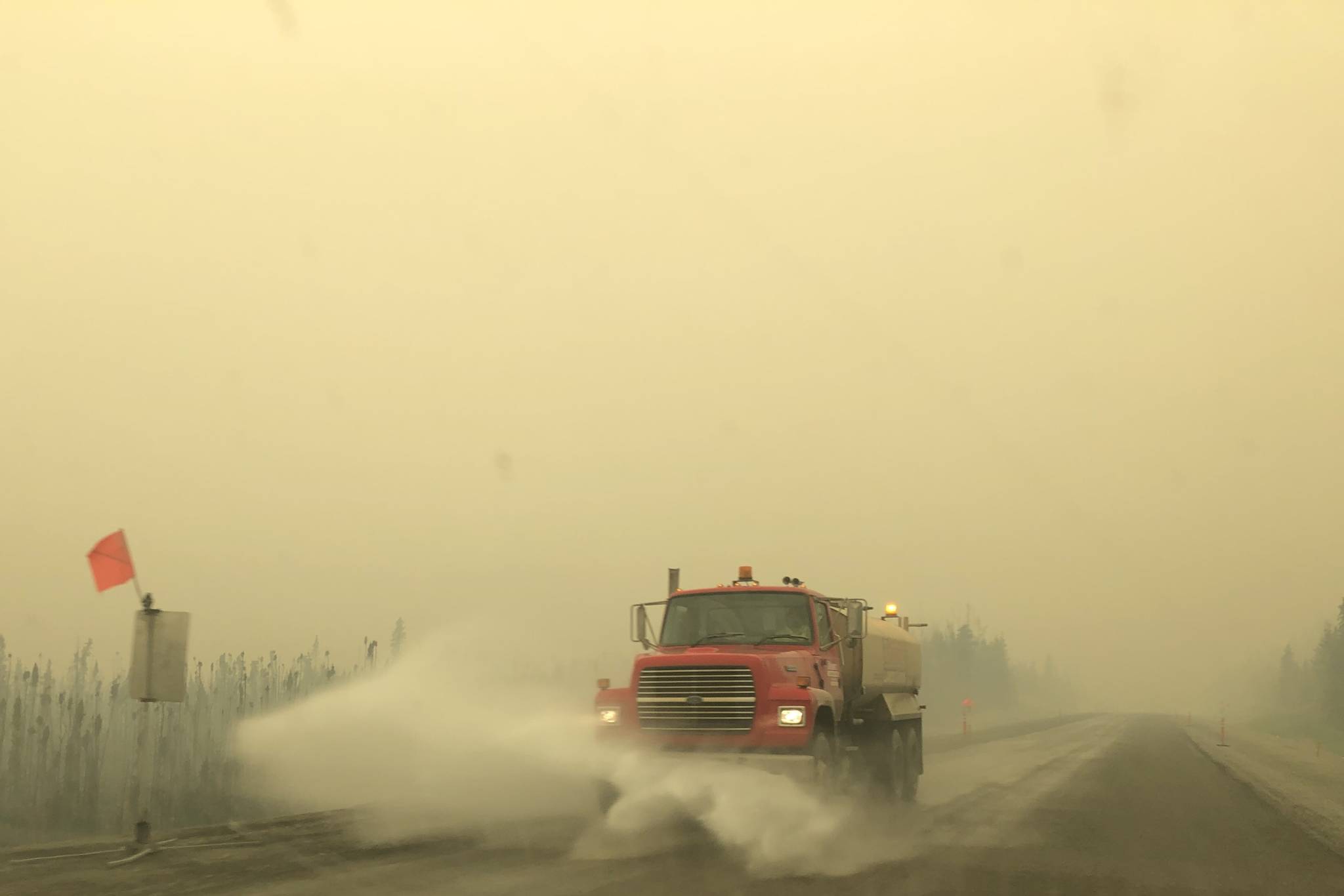Victoria Petersen / Peninsula Clarion                                A truck on the Sterling Highway plows through ash produced by the Swan Lake Fire on Tuesday.