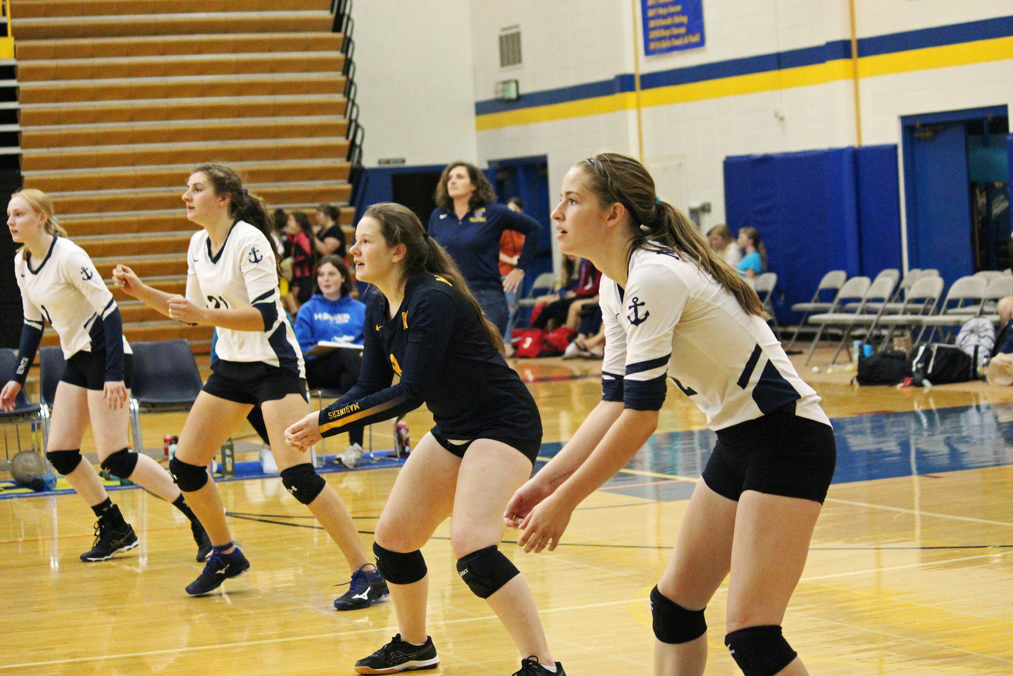 The back row of Homer volleyball players prepare to receive a serve from the Nikiski Bulldogs during a game at the Homer Jamboree tournament on Saturday, Aug. 24, 2019 in the Alice Witt Gymnasium in Homer, Alaska. (Photo by Megan Pacer/Homer News)