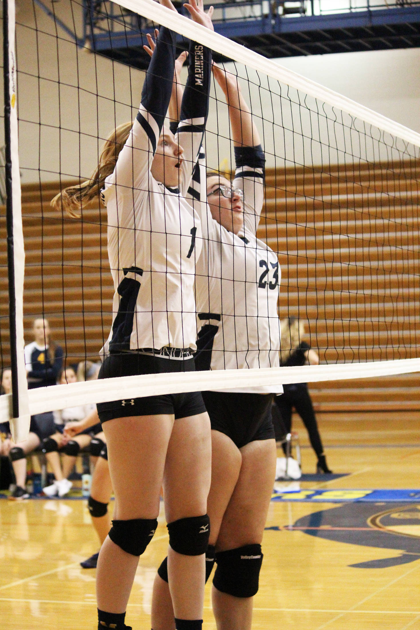 Homer’s Kelli Bishop (left) and Tonda Smude (right) jump to block a shot from the Nikiski Bulldogs during a Saturday, Aug. 24, 2019 volleyball game during the Homer Jamboree tournament in the Alice Witt Gymnasium in Homer, Alaska. (Photo by Megan Pacer/Homer News)