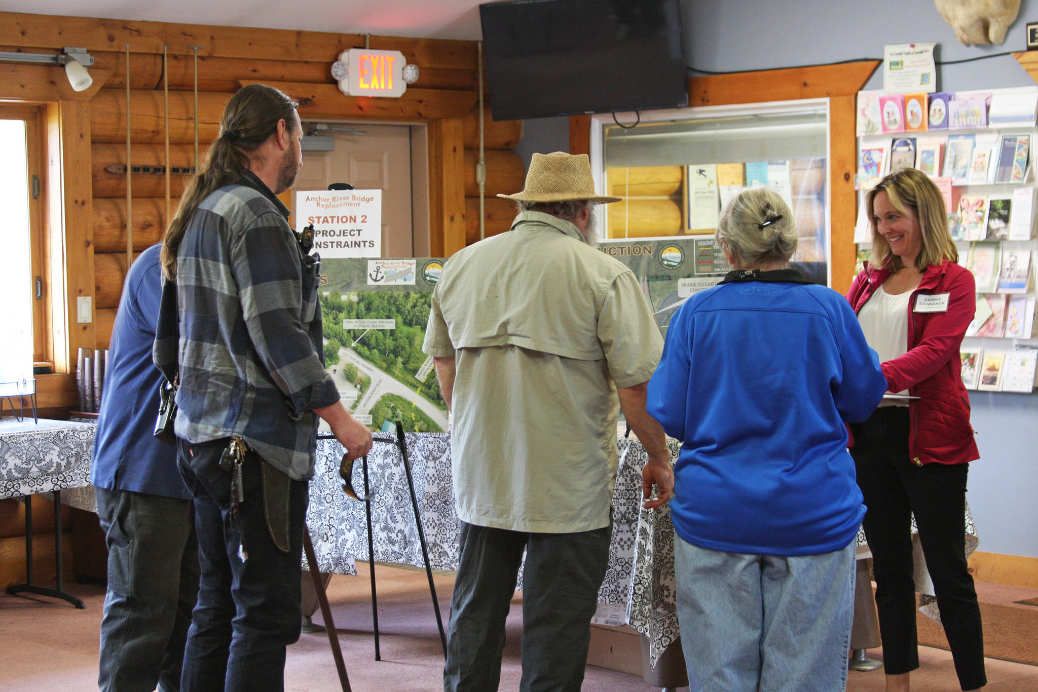Local Anchor Point residents view the presentation and chat with Carrie Connaker from Solstice Alaska Consulting, Inc., at the open house for the Anchor River Bridge replacement project on Tuesday, Aug. 20, 2019 at the Anchor Point Senior Center in Anchor Point, Alaska. (Photo by Delcenia Cosman)