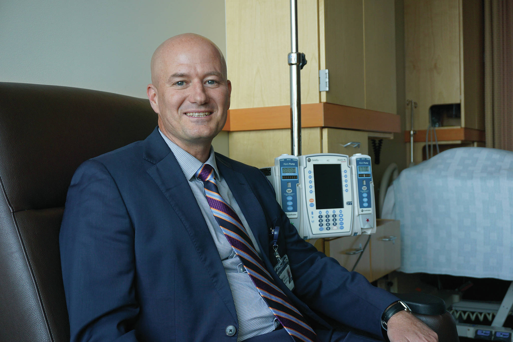 New South Peninsula Hospital Chief Executive Officer Ryan Smith poses for a photo in a visiting chair in one of the patient rooms on his first official day of work, Aug. 26, 2019, in Homer, Alaska. (Photo by Michael Armstrong/Homer News)
