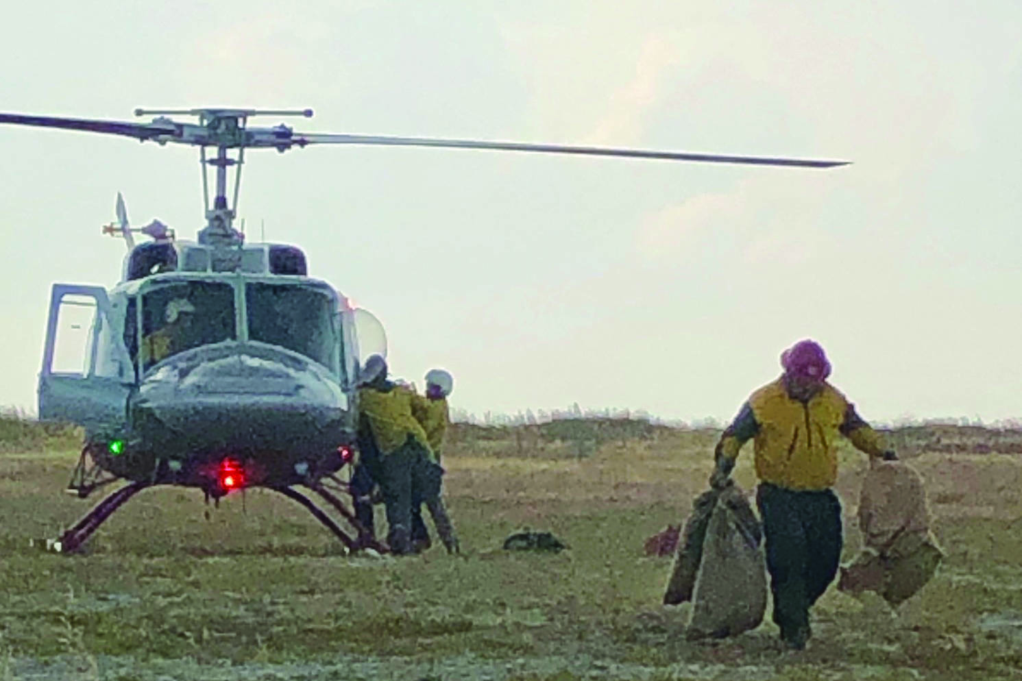 Firefighters unload supplies from a helicopter at the Caribou Lake Fire on Monday, Aug 26, 2019, northeast of Homer, Alaska. (Photo by Sarah Saarloos/Alaska Division of Forestry)
