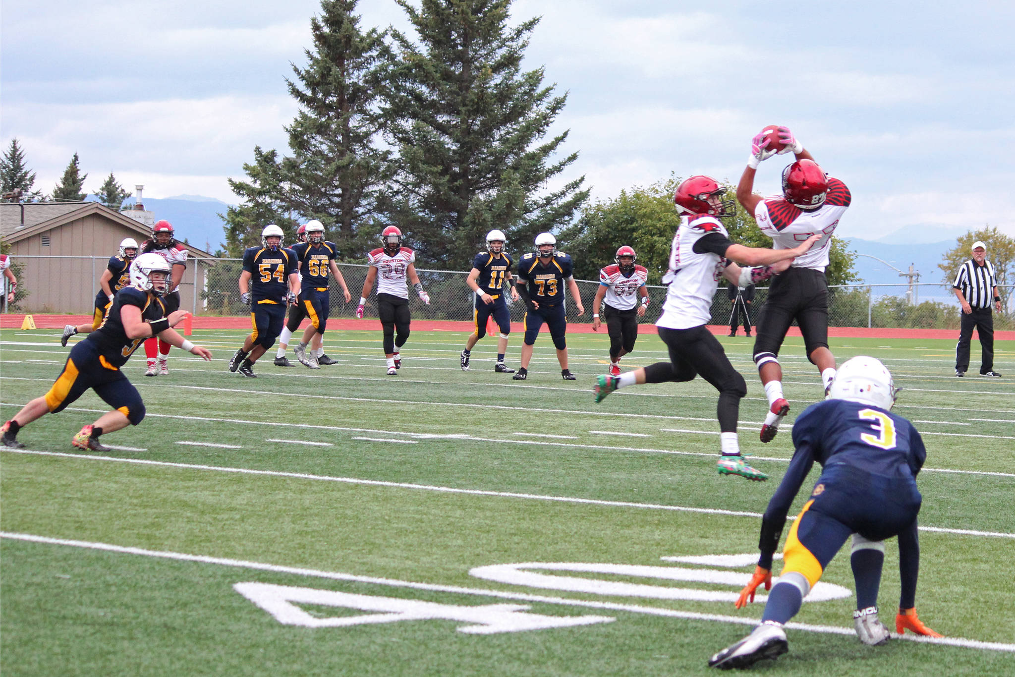 Houston’s Apete Sasiu intercepts a pass from Homer’s Josh Bradshaw before marking a touchdown during a Friday, Sept. 6, 2019 football game between the two teams at Homer High School in Homer, Alaska. (Photo by Megan Pacer/Homer News)