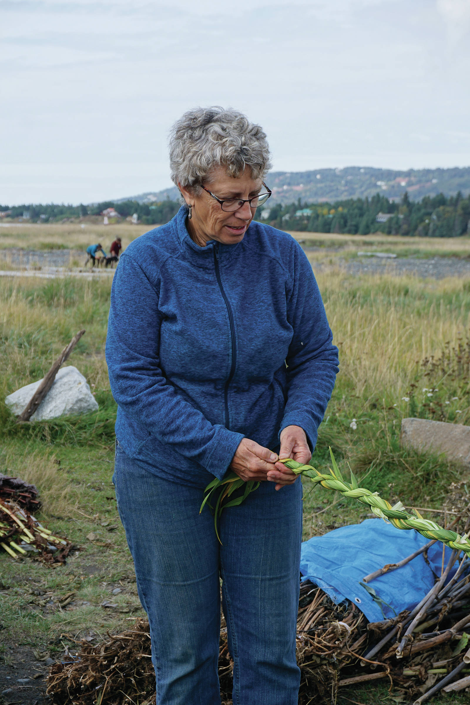 Peggy Gavillot weaves leaves for the 16th annual Burning Basket, Radiate, on Tuesday, Sept. 10, 2019, at Mariner Park on the Homer Spit. (Photo by Michael Armstrong/Homer News)