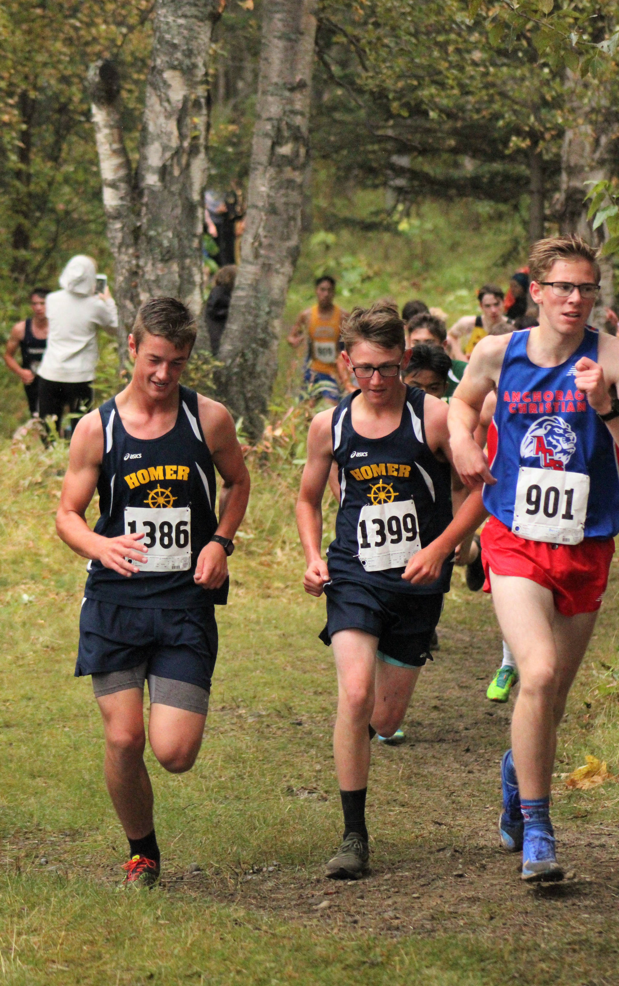 Homer’s Clayton Beachy, left, and Devin Wise, center, run together in the boys Division II cross country race Saturday, Sept. 7, 2019 at the Palmer Invite in Palmer, Alaska. (Photo by Tim Rockey/Frontiersman)
