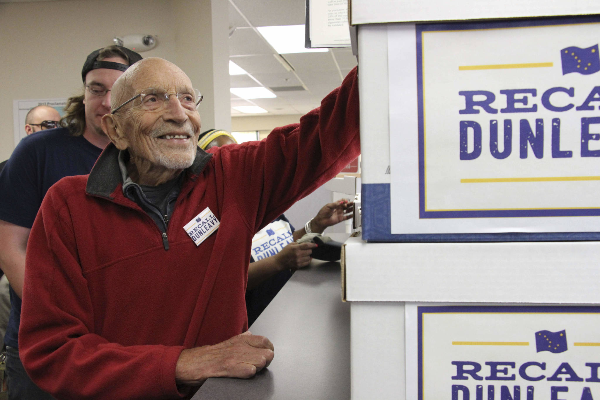 Vic Fischer, the last living person to help write the Alaska State Constitution, is shown smiling while looking at boxes of signatures to recall Alaska Gov. Mike Dunleavy that were delivered to the Alaska Division of Elections office in Anchorage on Thursday, Sept. 5. Fischer is one of the recall organizers, who say they submitted 49,0006 signatures in in an attempt to force the recall election of the first-term governor. (AP Photo/Mark Thiessen)