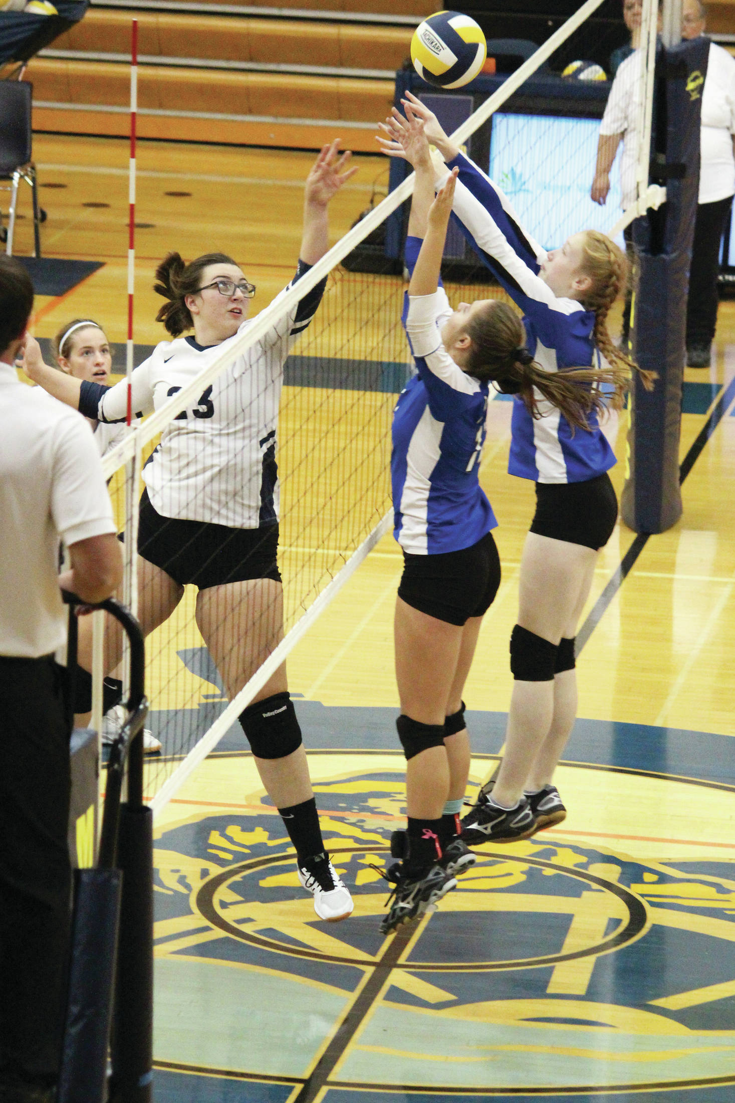 Palmer’s Kristen Beames (center) and Carli Bowen (right) jump to block a tip from Homer’s Tonda Smude during a Thursday, Sept. 12, 2019 volleyball game in the Alice Witte Gymnasium in Homer, Alaska. (Photo by Megan Pacer/Homer News)
