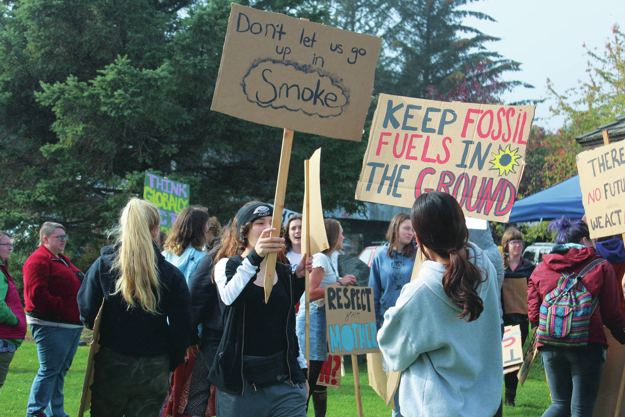 Students gather in Wisdom, Knowledge, Faith and Love Park carrying signs advocating action against climate change during the Homer Youth Climate Strike on Friday, Sept. 20, 2019 in Homer, Alaska. Students were joined by community members and left their last period of school to walk down to the park. (Photo by Megan Pacer/Homer News)
