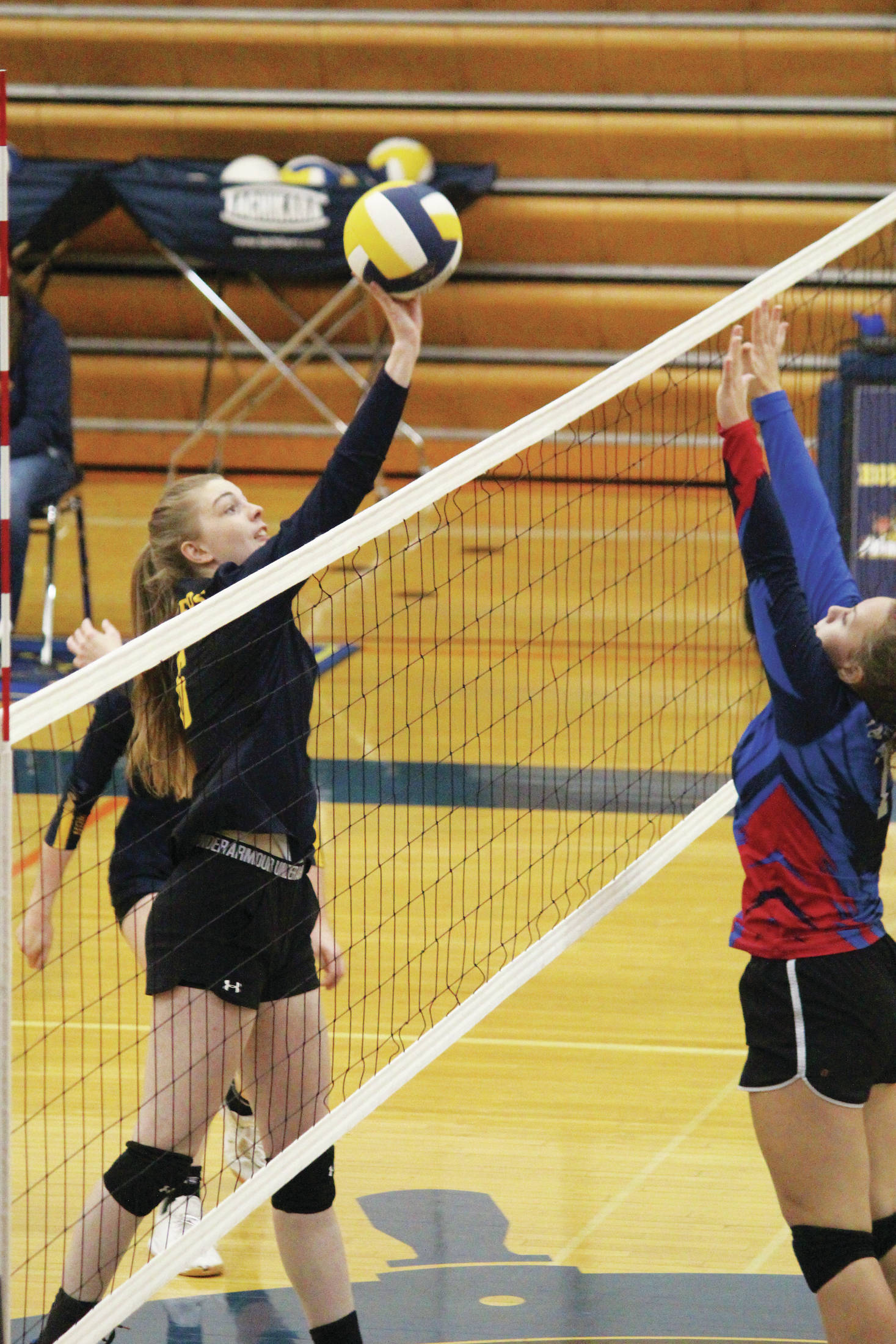 Homer’s Karmyn Gallios tips the ball over the net to the Anchorage Christian Schools Lions during a Saturday, Sept. 28, 2019 volleyball game in the Alice Witte Gymnasium in Homer, Alaska. (Photo by Megan Pacer/Homer News)
