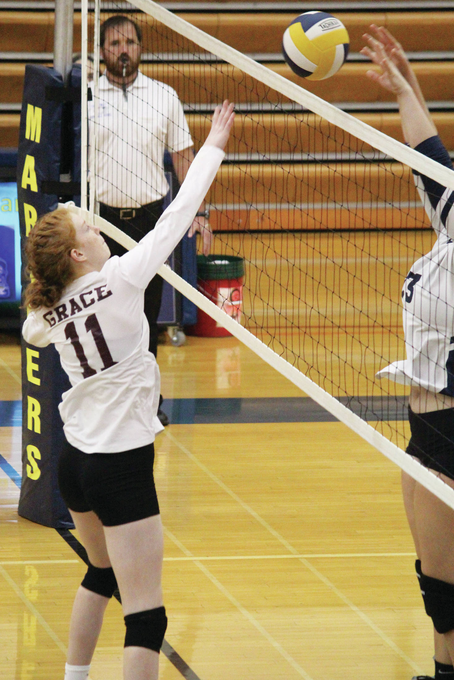 Rachel McGovern of Grace Christian Schools tips the ball over the net to the Homer Mariners during a Friday, Sept. 27, 2019 volleyball game at the Alice Witte Gymnasium in Homer, Alaska. (Photo by Megan Pacer/Homer News)