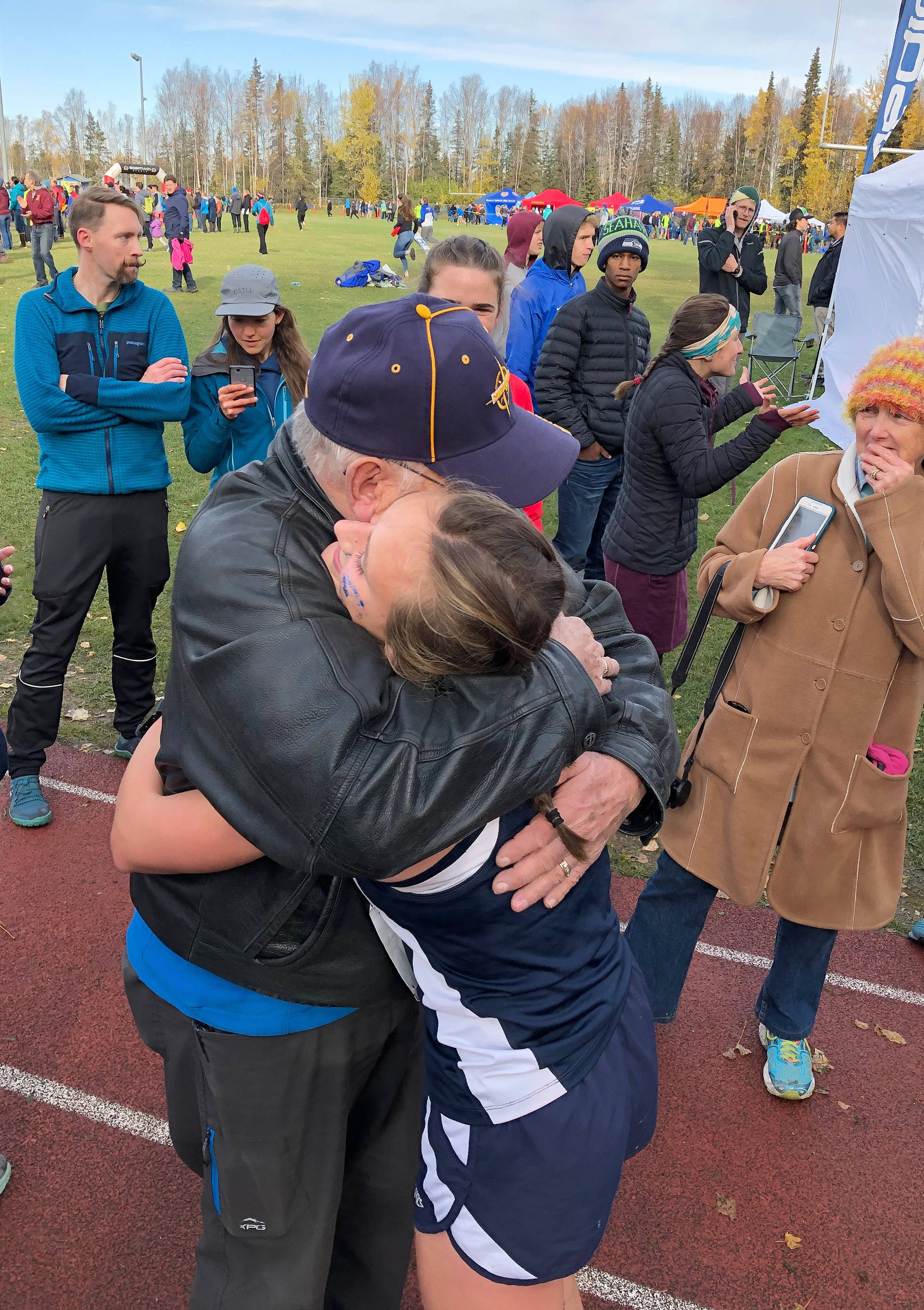 Homer’s Autumn Daigle hugs a family member after winning the Div. II girls state cross-country championship Saturday, Oct. 5, 2019, on the Bartlett High trails in Anchorage, Alaska. (Photo by Joey Klecka/Peninsula Clarion)