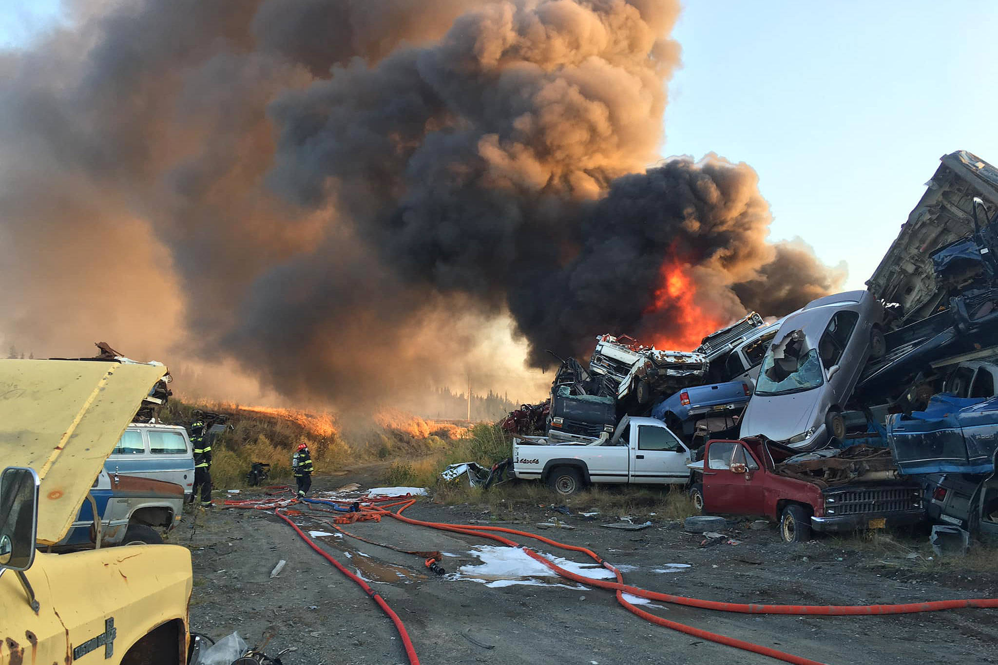 Firefighters work to extinguish a fire in a pile of scrap vehicles on Greenfield Road on Sunday, Oct. 6, 2019 in Anchor Point, Alaska. (Photo courtesy Anchor Point Fire and Emergency Services)
