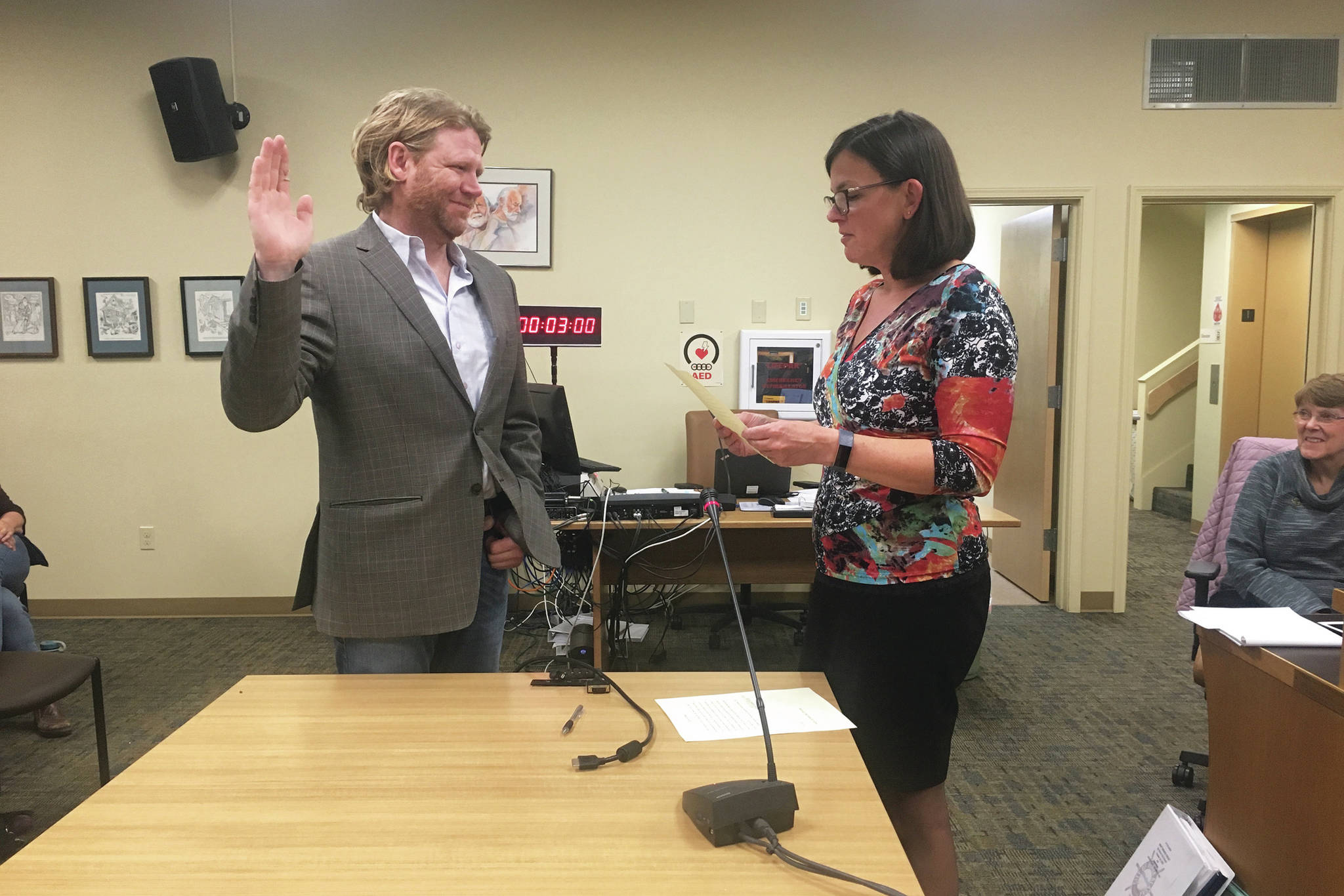Joey Evensen is sworn in as a new member of the Homer City Council by City Clerk Melissa Jacobsen at a Monday, Oct. 14, 2019 council meeting at Homer City Hall in Homer, Alaska. Evensen won one of two open seats on the council with the majority of votes in the Oct. 1 municipal election. (Photo by Megan Pacer/Homer News)