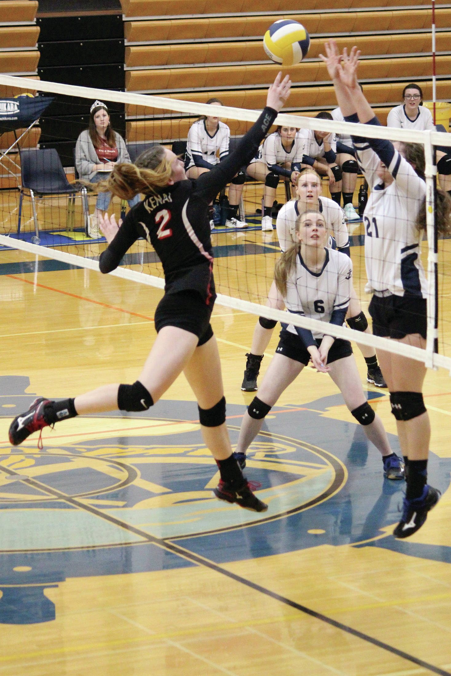 Kenai’s Bethany Morris tips the ball over the net while Homer’s Marina Carroll jumps to block during a Tuesday, Oct. 20, 2019 volleyball game between the two schools at the Alice Witte Gymnasium in Homer, Alaska. It was the last home game of the season for the Mariners. (Photo by Megan Pacer/Homer News)