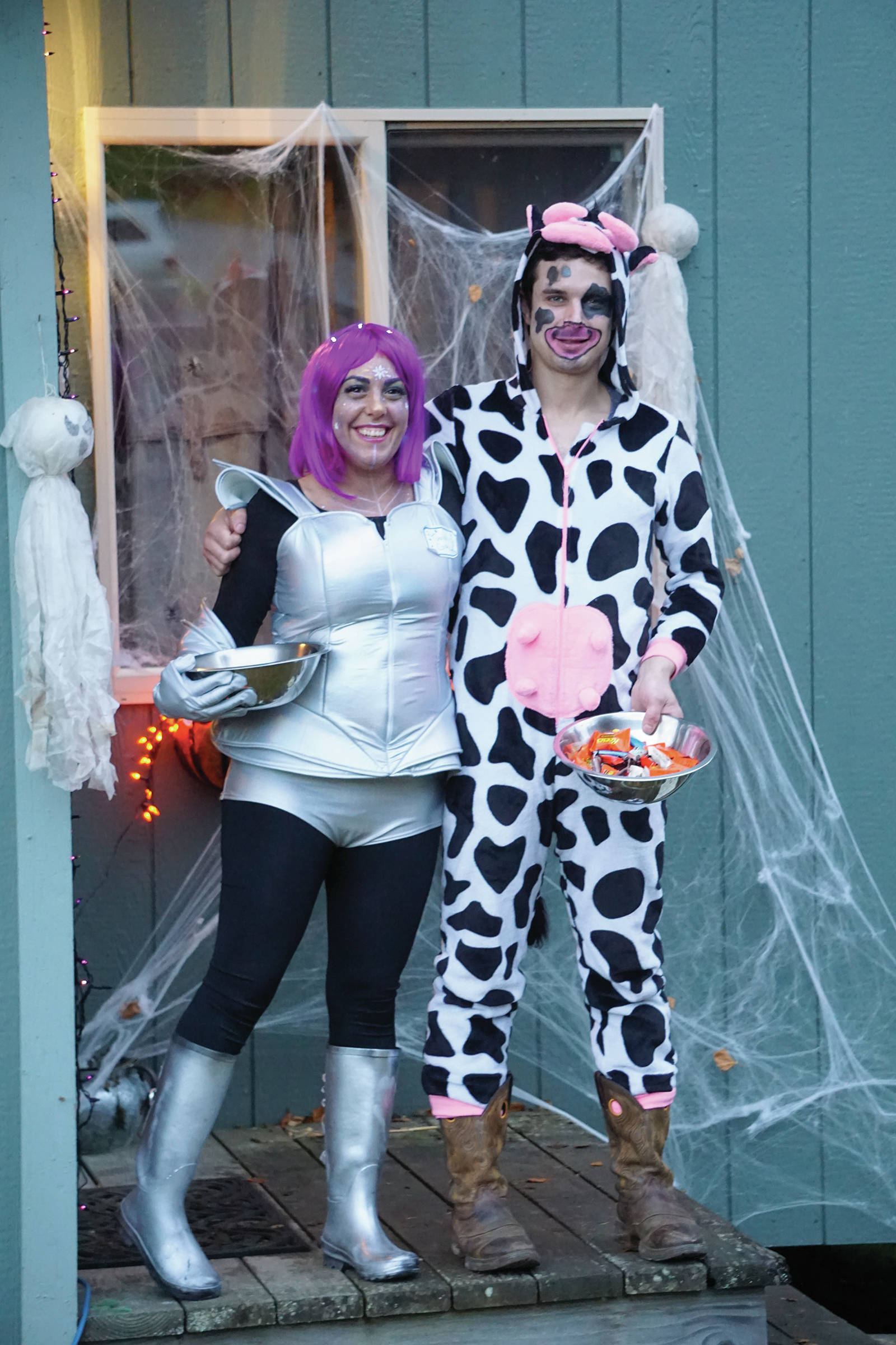 Mandy Jahanbin, left, and Nick Dufour, right, hand on candy for Halloween on Oct. 31, 2019, in Homer, Alaska. (Photo by Michael Armstrong/Homer News)