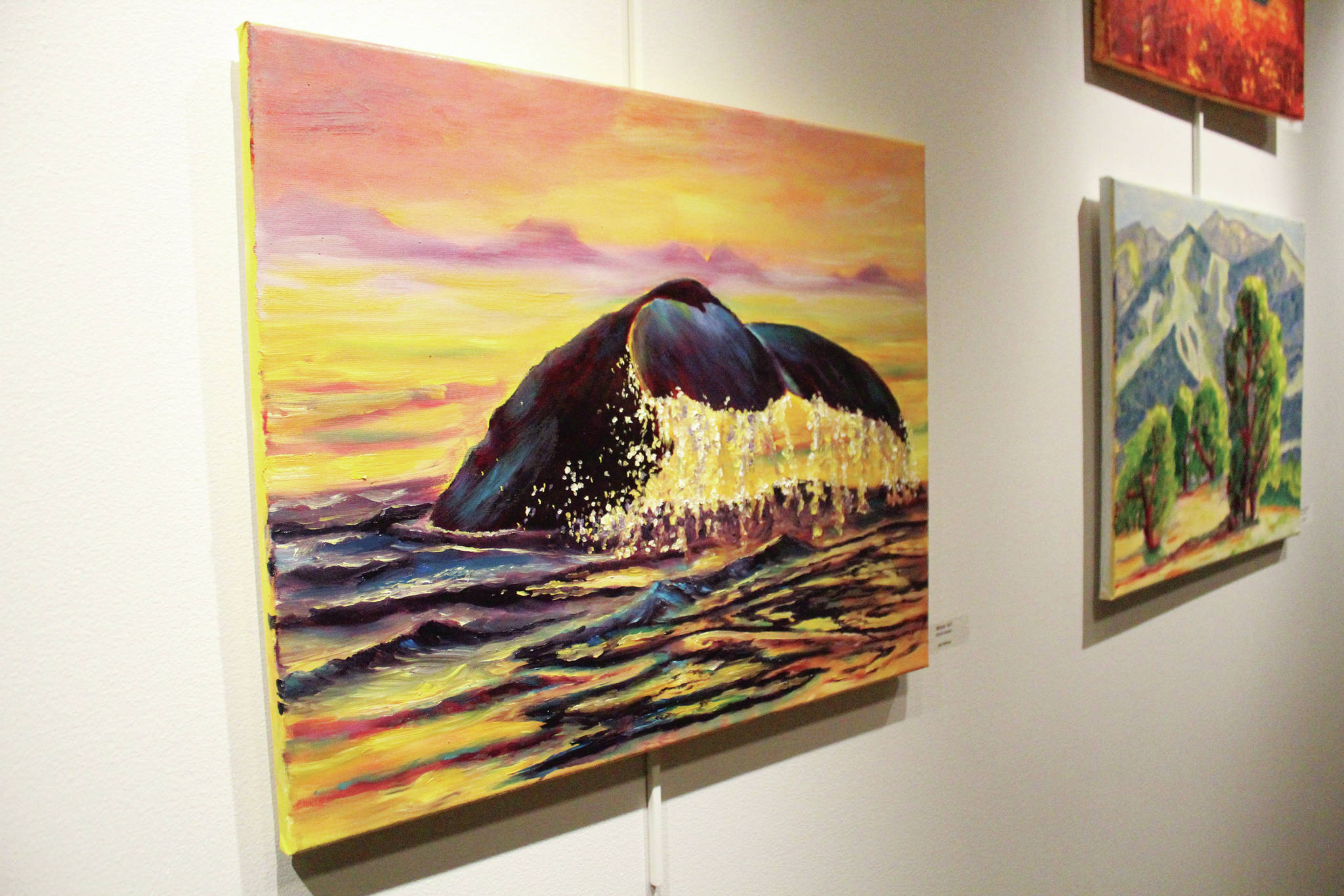 Paintings by students in Asia Freeman’s art class taught at Kachemak Bay Campus hang on the wall during a First Friday art exhibit opening Friday, Nov. 1, 2019 at the campus in Homer, Alaska. (Photo by Megan Pacer/Homer News)