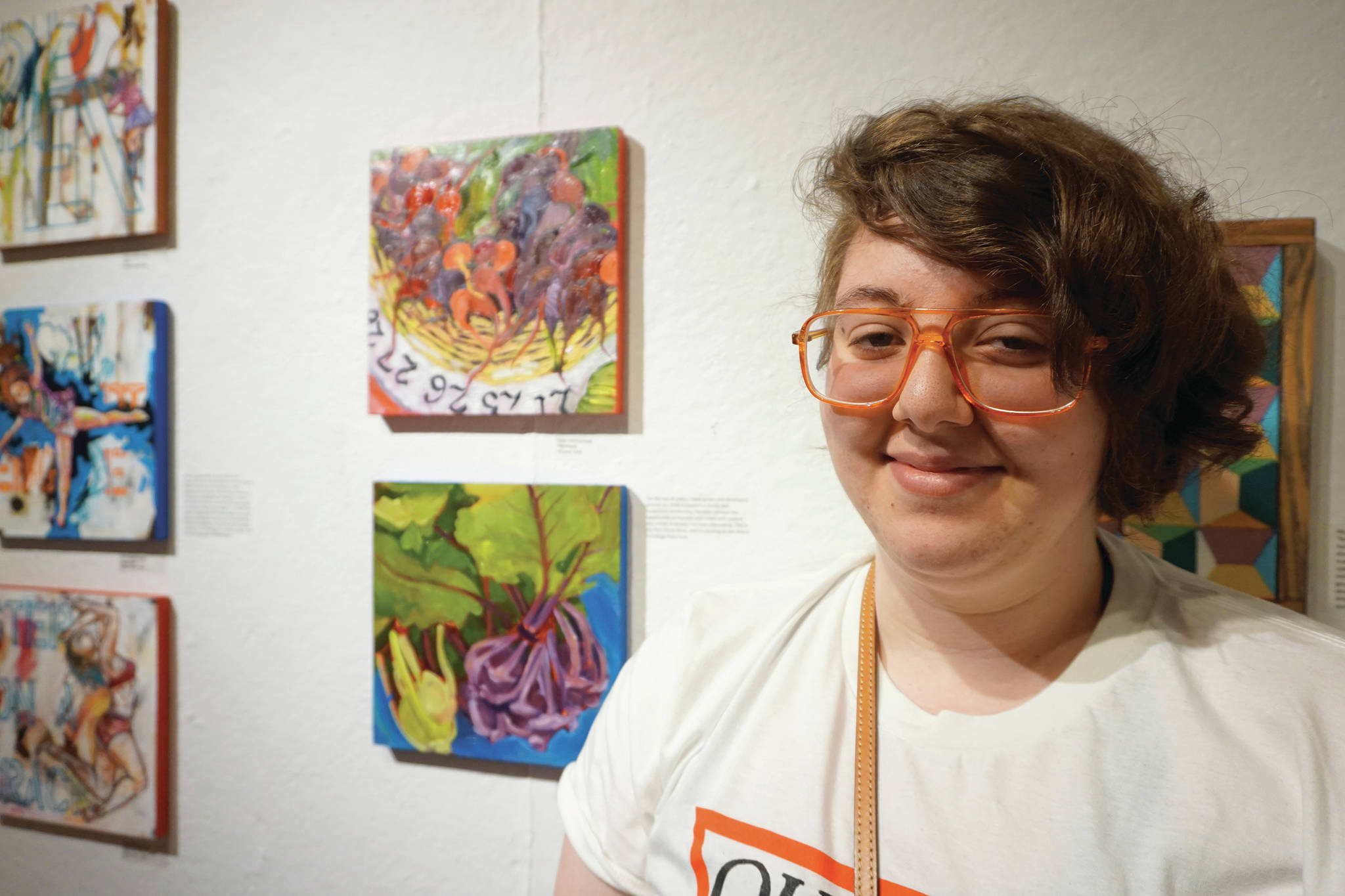 Drew Wimmerstedt stands by two of her works in the 10x10 show at Bunnell Street Arts Center that opened on Nov. 8, 2019, in Homer, Alaska. (Photo by Michael Armstrong/Homer News)