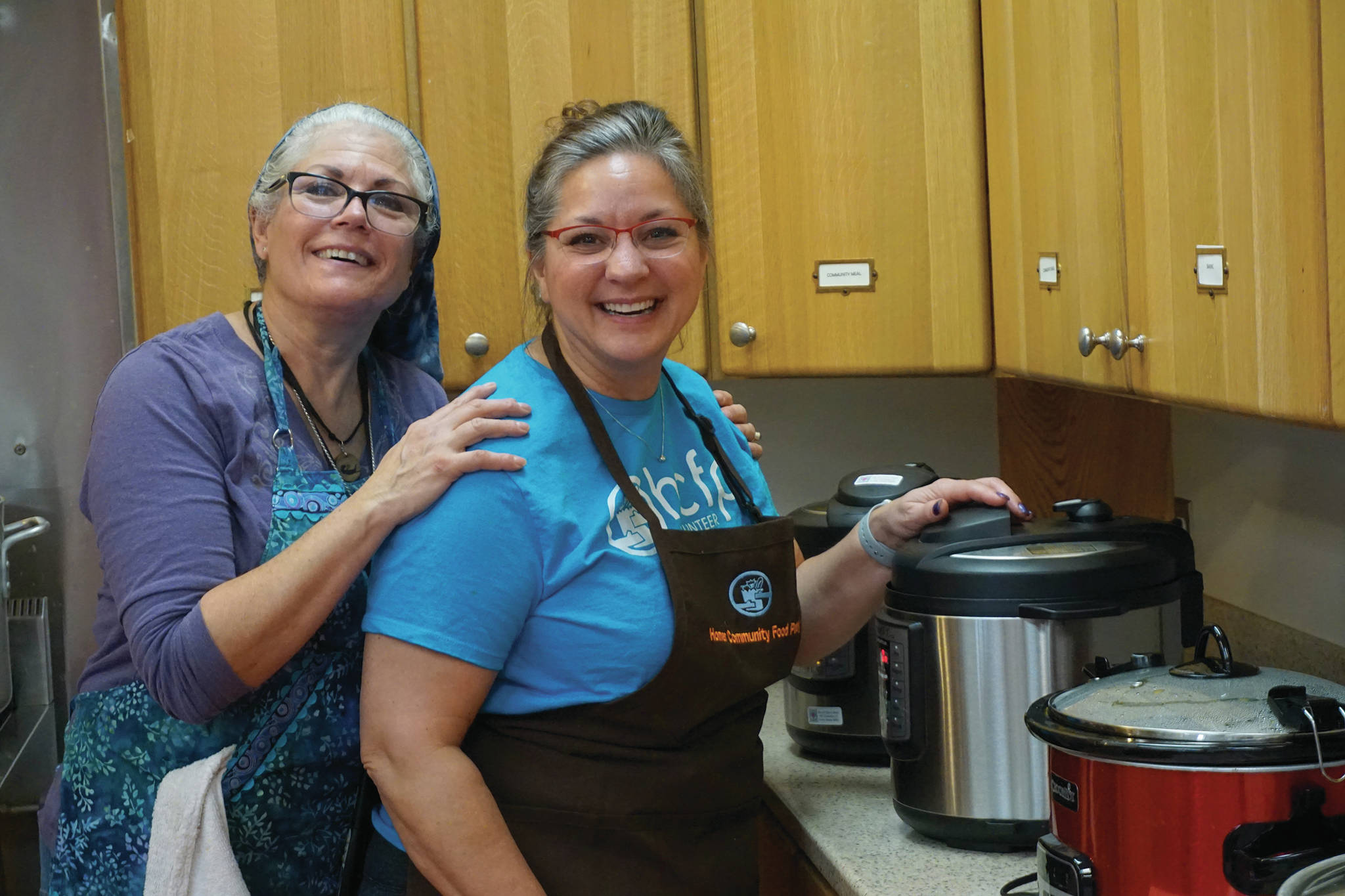 Susan Pacillo, left, and Cinda Martin, right, warm up soup at the annual Homer Community Food Pantry’s Empty Bowls fundraiser on Friday, Nov. 8, 2019, at Homer United Methodist Church in Homer, Alaska. (Photo by Michael Armstrong/Homer News)