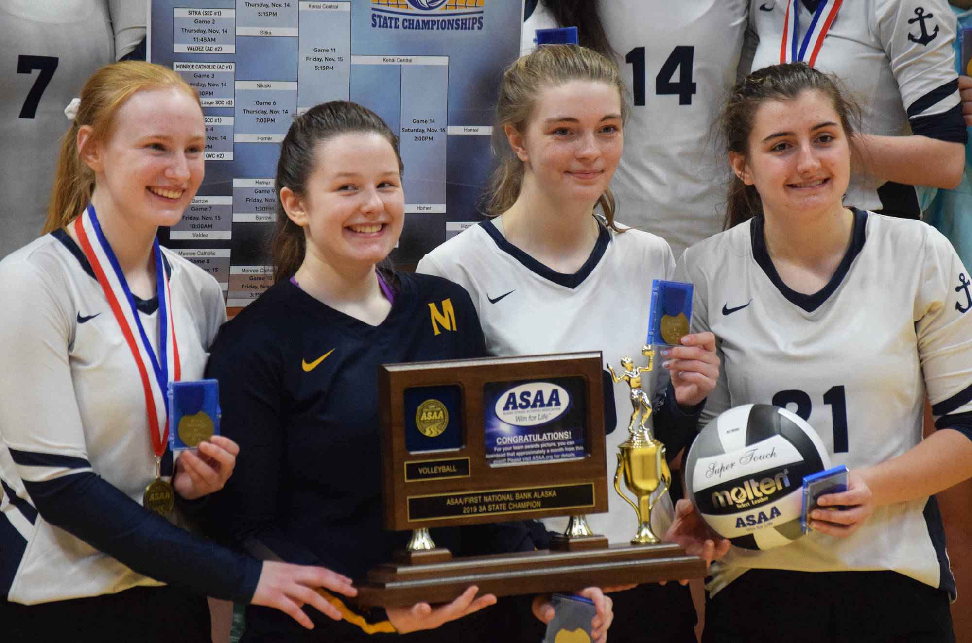 Members of the Homer volleyball team hold up the Class 3A state championship trophy Saturday at the Class 3A state volleyball tournament at the Alaska Airlines Center in Anchorage. (Photo by Joey Klecka/Peninsula Clarion)