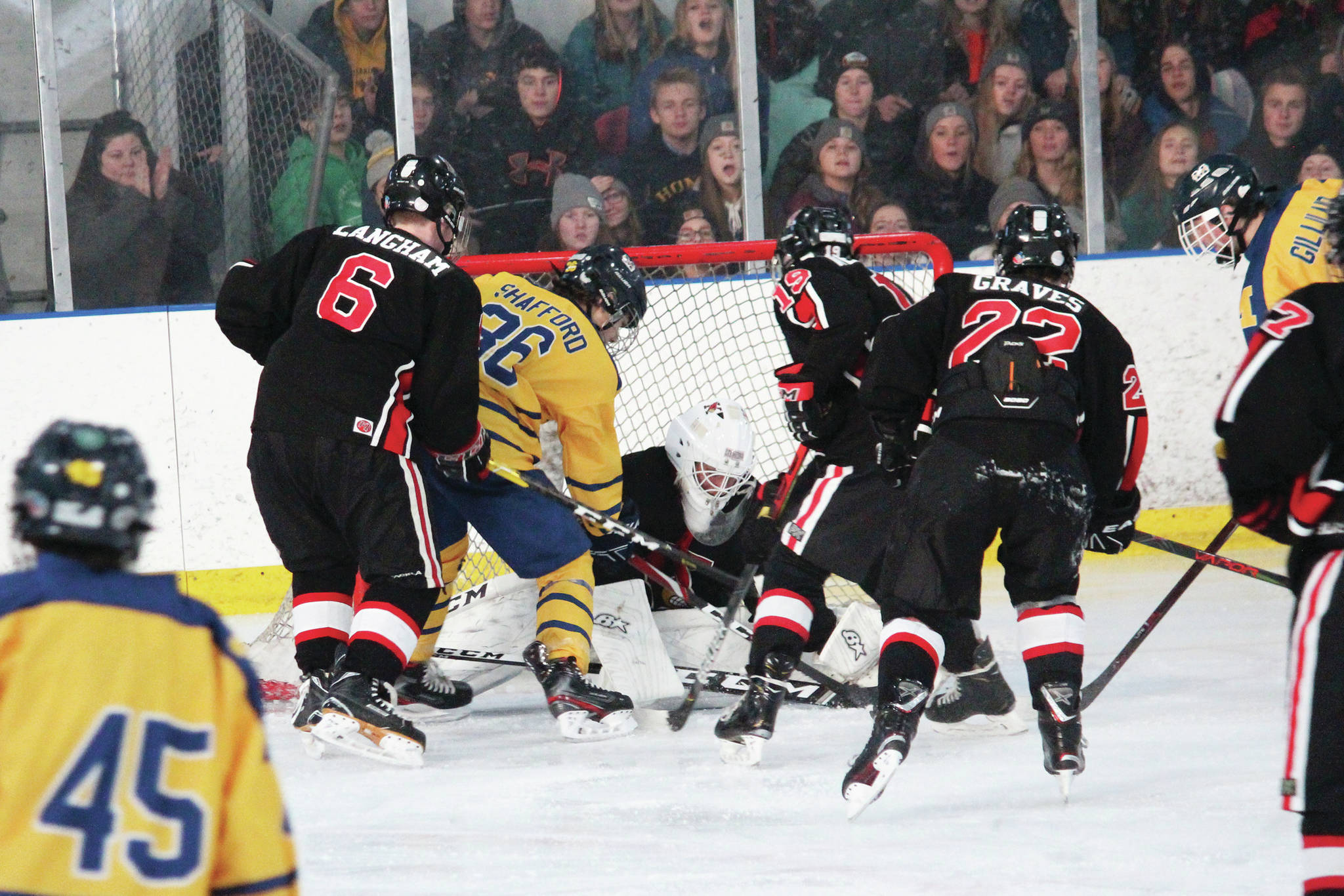 Homer’s Austin Shafford tries to force the puck into the net amid a crowd of Kenai defenders during a Saturday, Nov. 23, 2019 hockey game at Kevin Bell Arena in Homer, Alaska. (Photo by Megan Pacer/Homer News)
