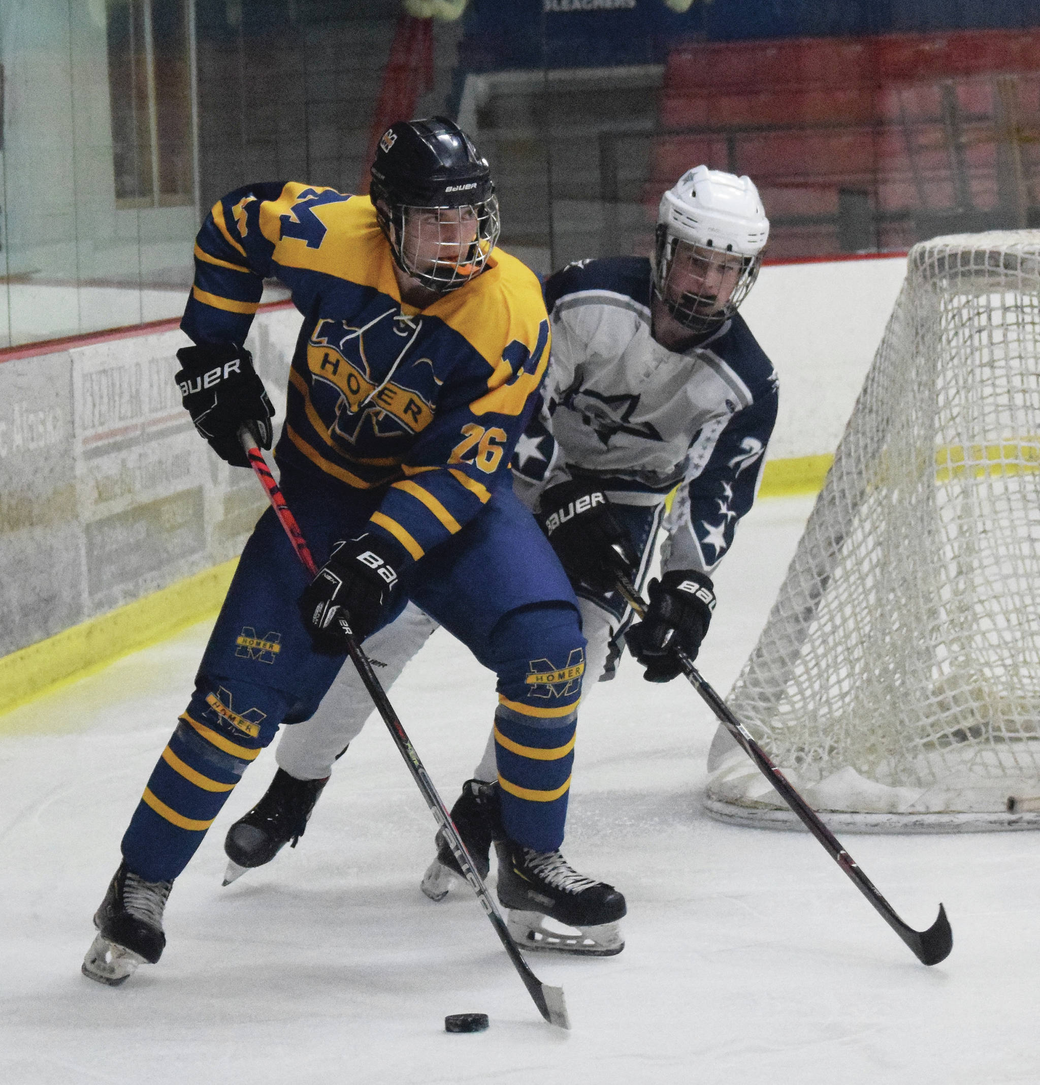 Soldotna’s Dylan Dahlgren chases Homer’s Ethan Pitzman around the back of the goal Friday at the Soldotna Regional Sports Complex in Soldotna, Alaska. (Photo by Joey Klecka/Peninsula Clarion)