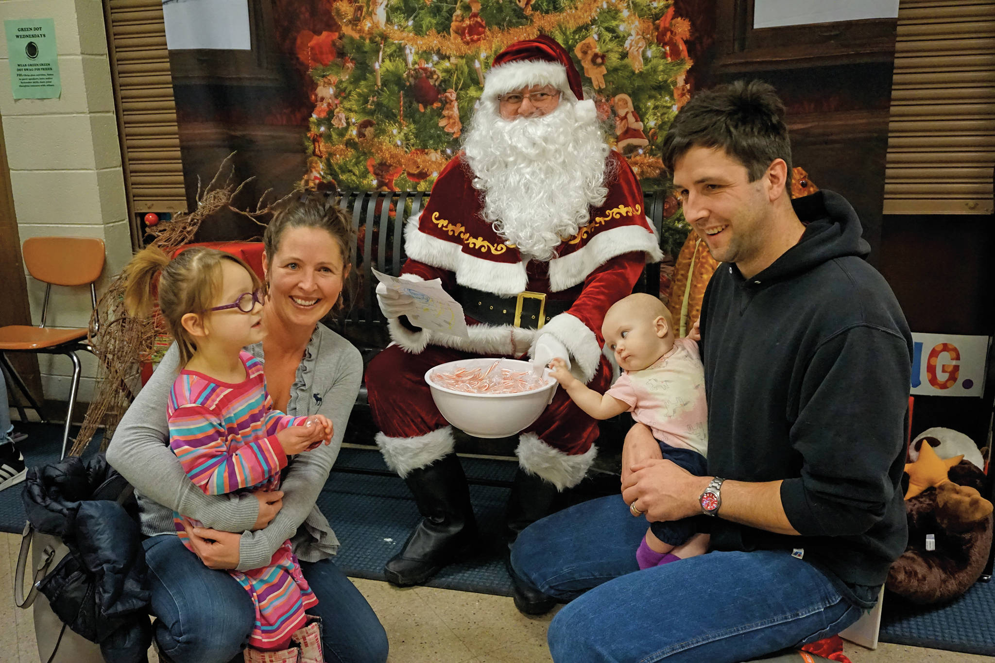 Sydney Jones, left, with her mother, Sarah Bollwitt, visits with Santa Claus on Sunday, Dec. 8, 2019, at the Homer Nutcracker Faire at Homer High School in Homer, Alaska. Sydney’s father, Morgan Jones, right, and sister, Jenaka, watch. Sydney had her mother write a letter to Santa Claus for her. (Photo by Michael Armstrong/Homer News)