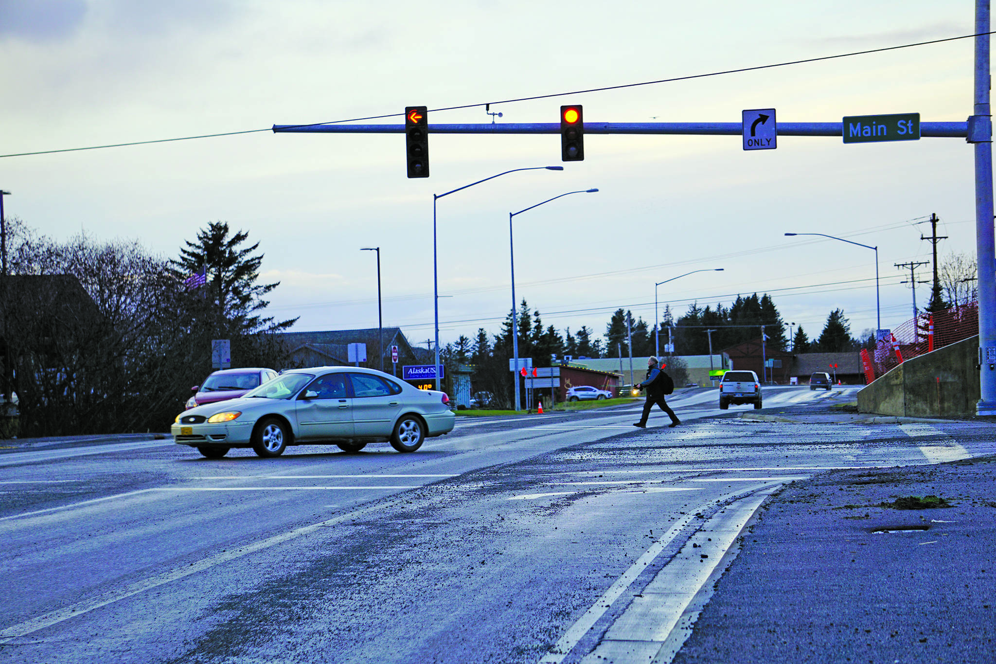 A man crosses the Homer Bypass Road as a driver turns left from Main Street onto the bypass using the new stoplight at the intersection. Homer’s second stoplight became operational on Tuesday, Dec. 10, 2019, in Homer, Alaska. (Photo by Michael Armstrong/Homer News)