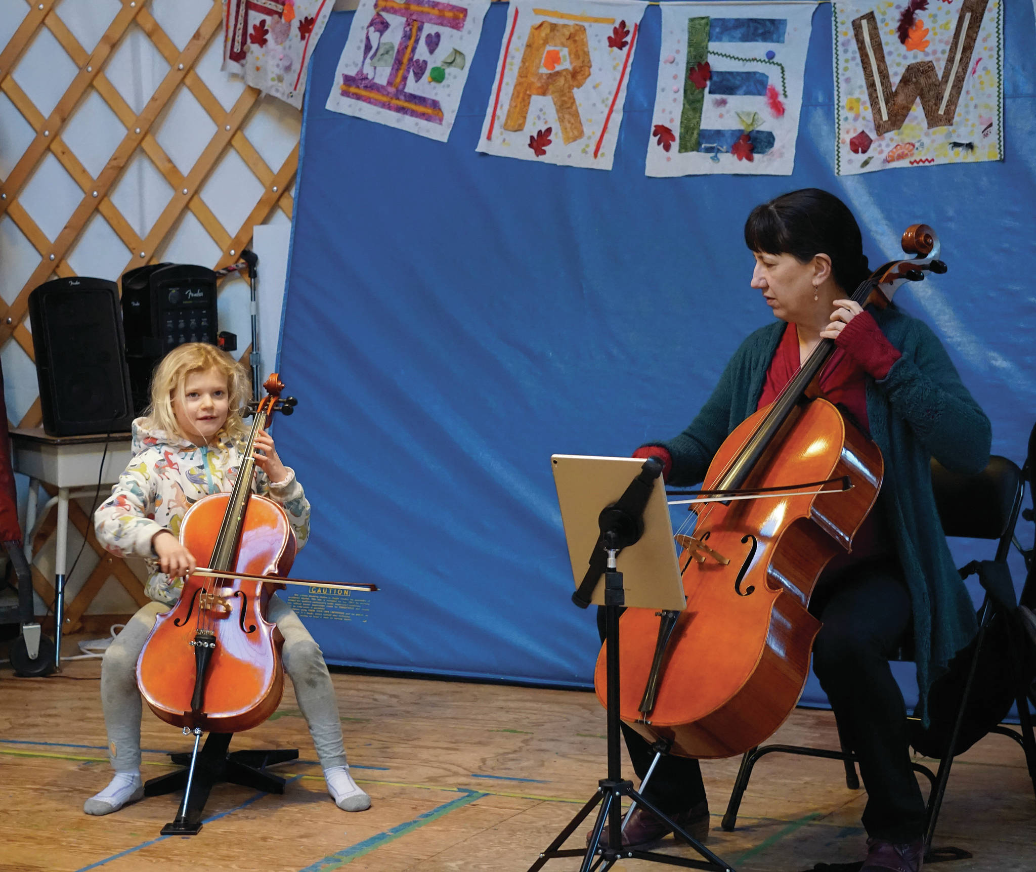 Nancy L. Ives, principal cellist for the Oregon Symphony Orchestra, Portland, plays with Lila Shavelson at Little Fireweed Academy on Friday, Dec. 20, 2019, in Homer, Alaska. Ives talked with Fireweed students about cycles, a theme they have been studying this year, and how they fit in music. She also performed for a concert fundraiser at the Pratt Museum that night. (Photo by Michael Armstrong/Homer News)