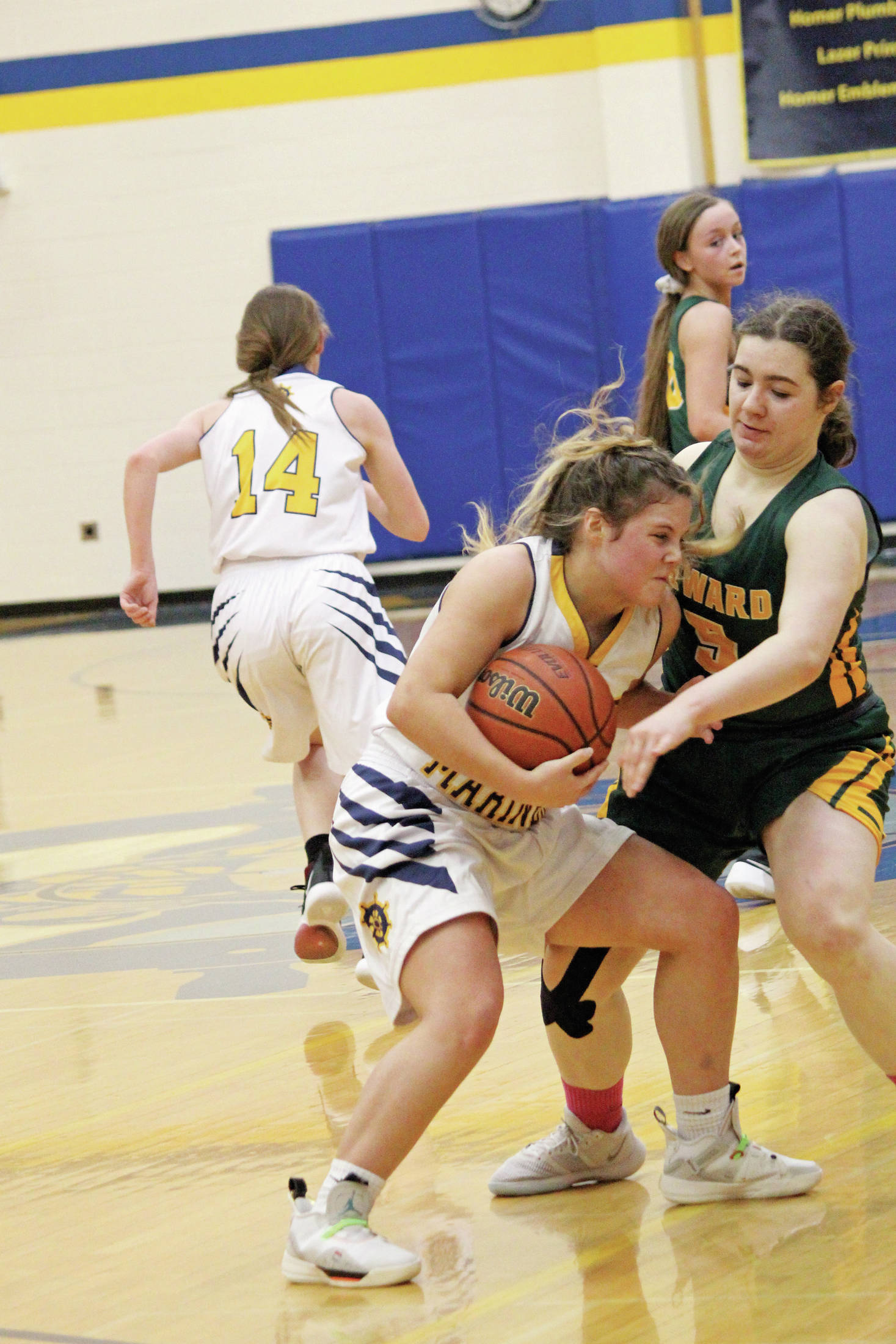 Homer’s Rylee Doughty wrestles the ball away from Seward’s Sophia Dow during a Saturday, Jan. 11, 2020 basketball game between the two schools at the Alice Witte Gymnasium in Homer, Alaska. (Photo by Megan Pacer/Homer News)