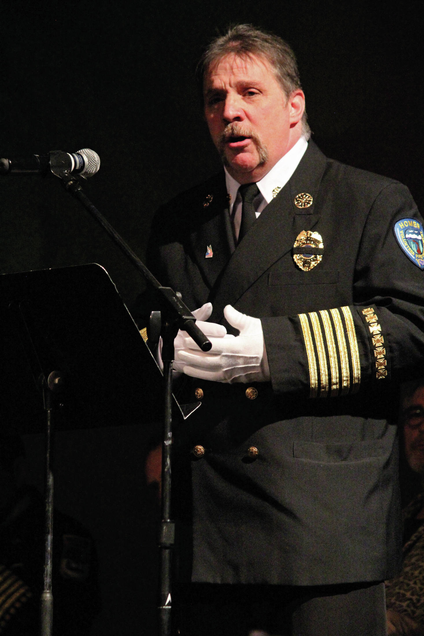 Homer Volunteer Fire Department Chief Mark Kirko speaks during a Sunday, Jan. 19, 2020 memorial for Homer resident Gary Thomas at the Homer Mariner Theatre at Homer High School in Homer, Alaska. Thomas, who was killed this month in a water heater explosion, was a volunteer firefighter for more than 40 years. (Photo by Megan PacerHomer News)